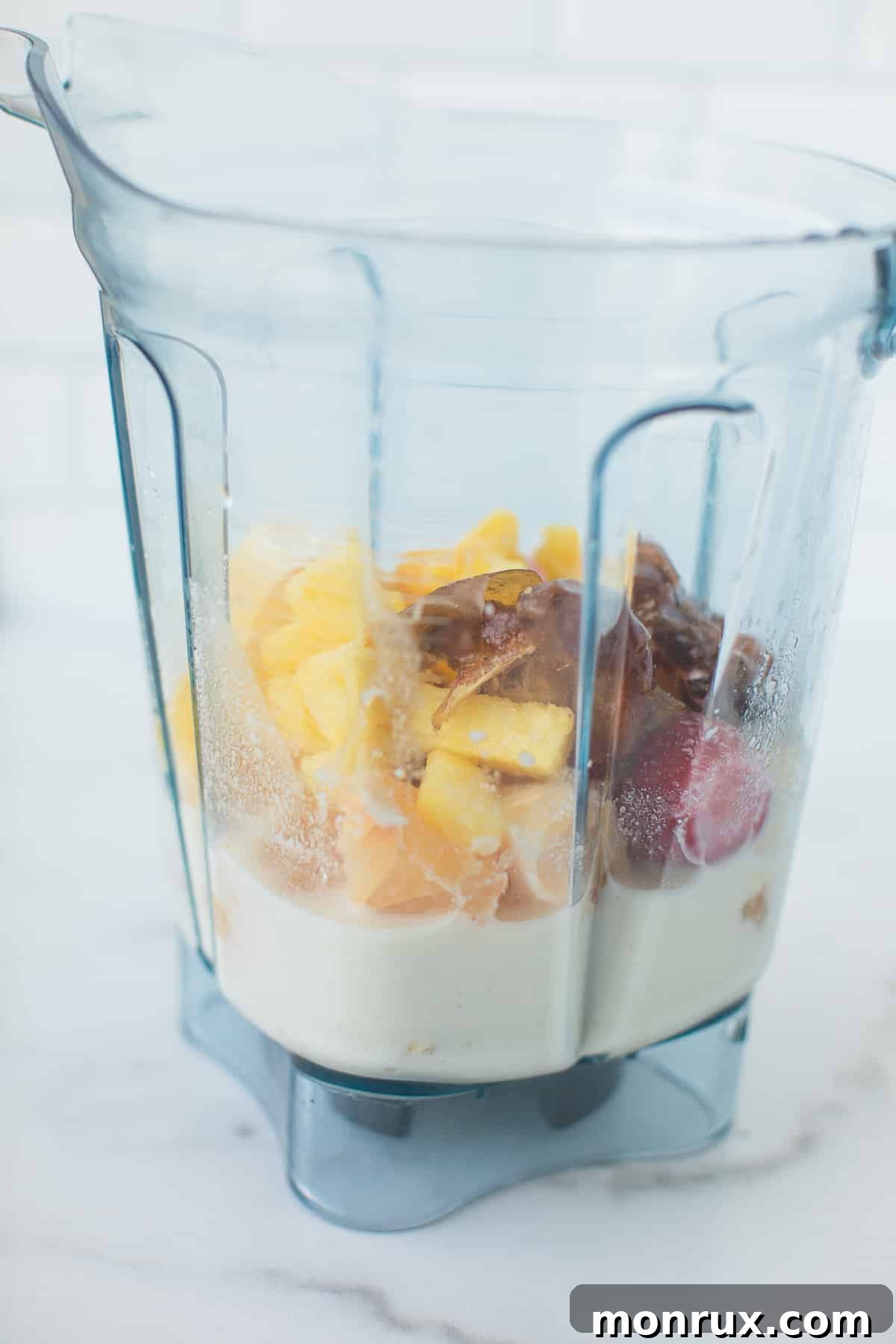All ingredients for the grapefruit smoothie placed into the base of a high-speed Vitamix blender, ready for blending.
