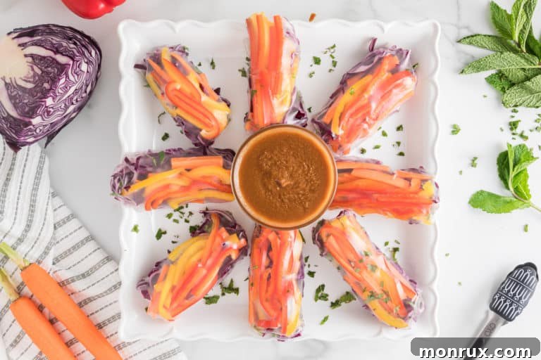 An appetizing platter filled with vibrant veggie summer rolls, accompanied by a small bowl of creamy peanut dipping sauce, ready to be served.