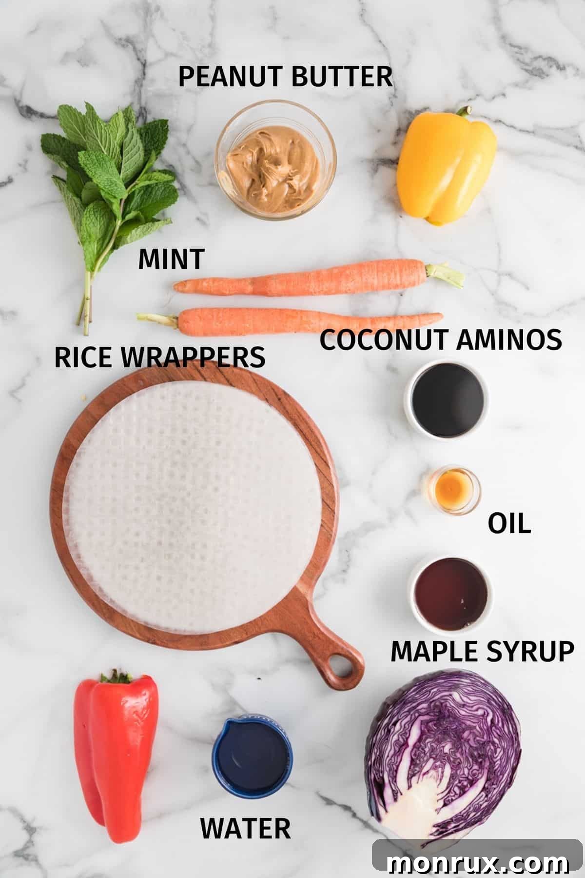 A flat lay photograph showcasing all the fresh ingredients needed to make delicious vegan summer rolls, arranged on a white surface.