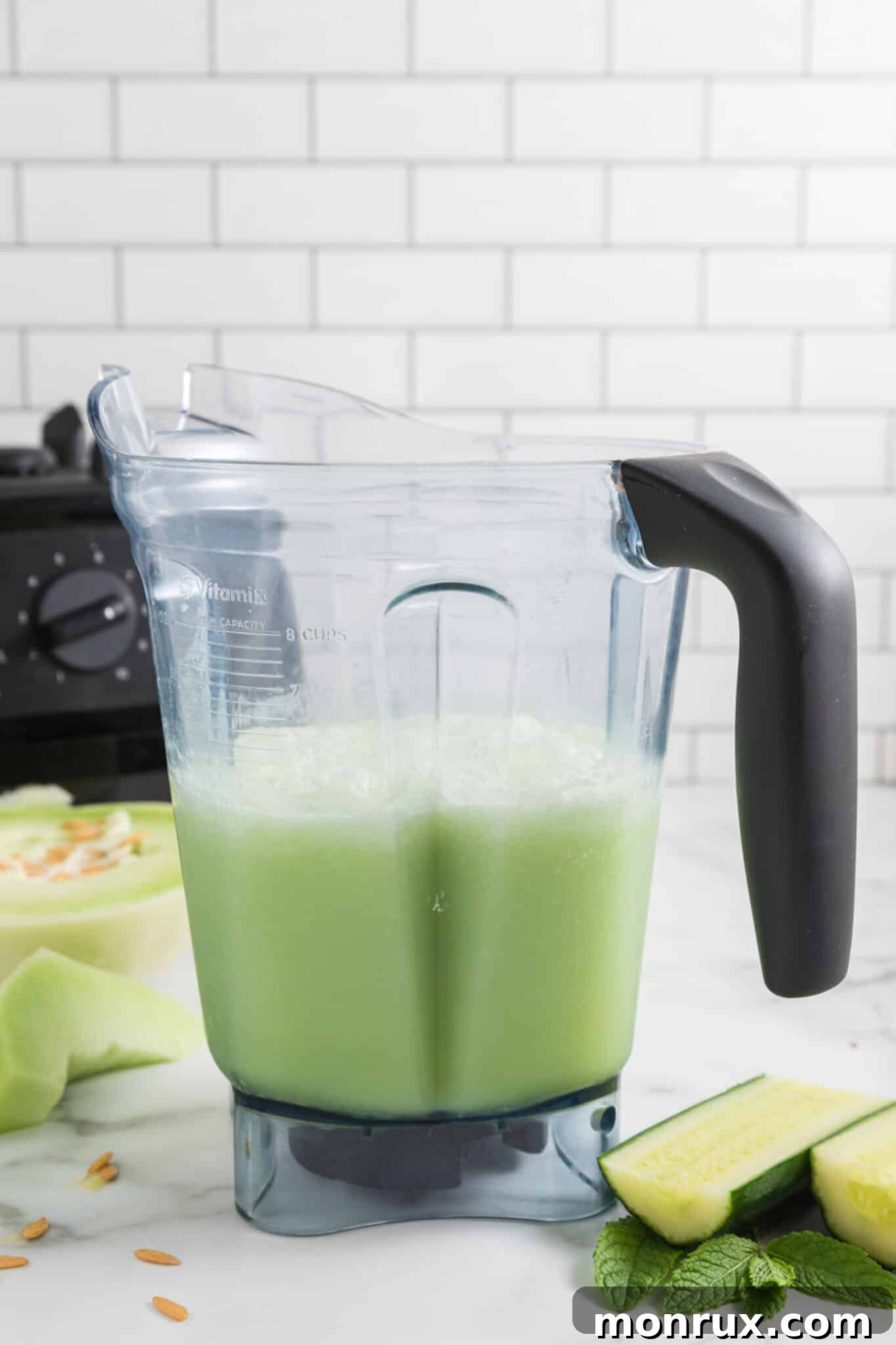 A blender jar filled with a thick, green Honeydew Cucumber Smoothie, showing its smooth consistency.