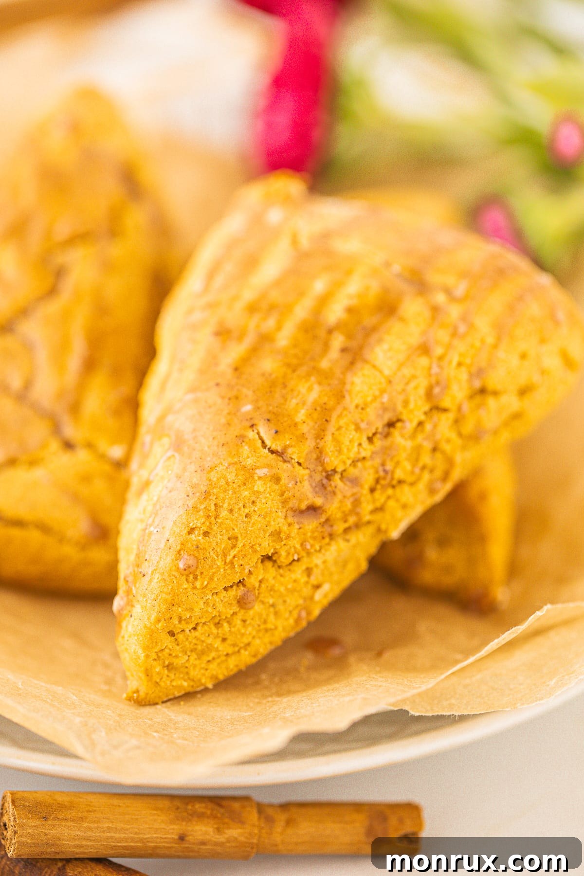 A perfectly baked pumpkin scone with a spiced glaze, ready to be enjoyed on a plate.