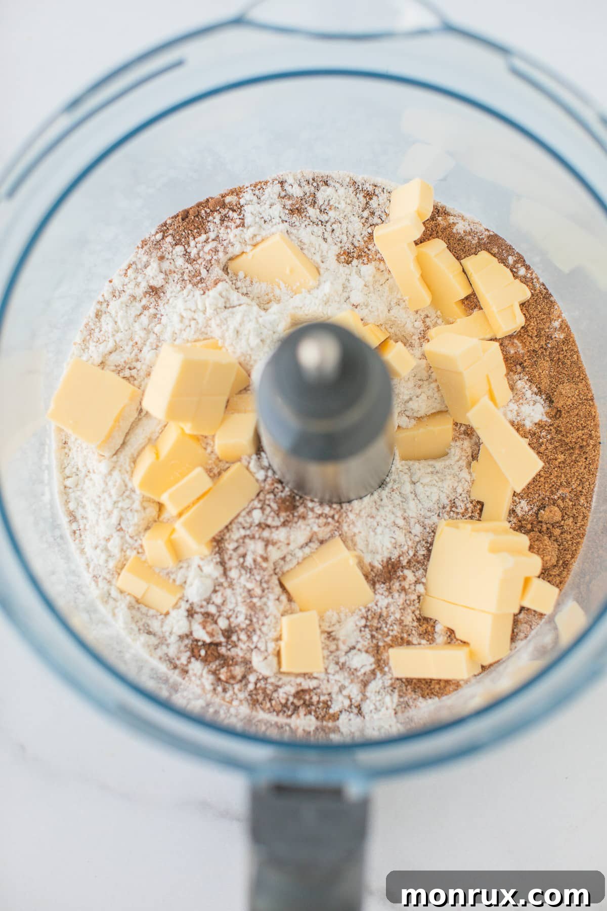Food processor bowl with flour and cold cubed butter, ready to be pulsed into a crumbly mixture for scones.