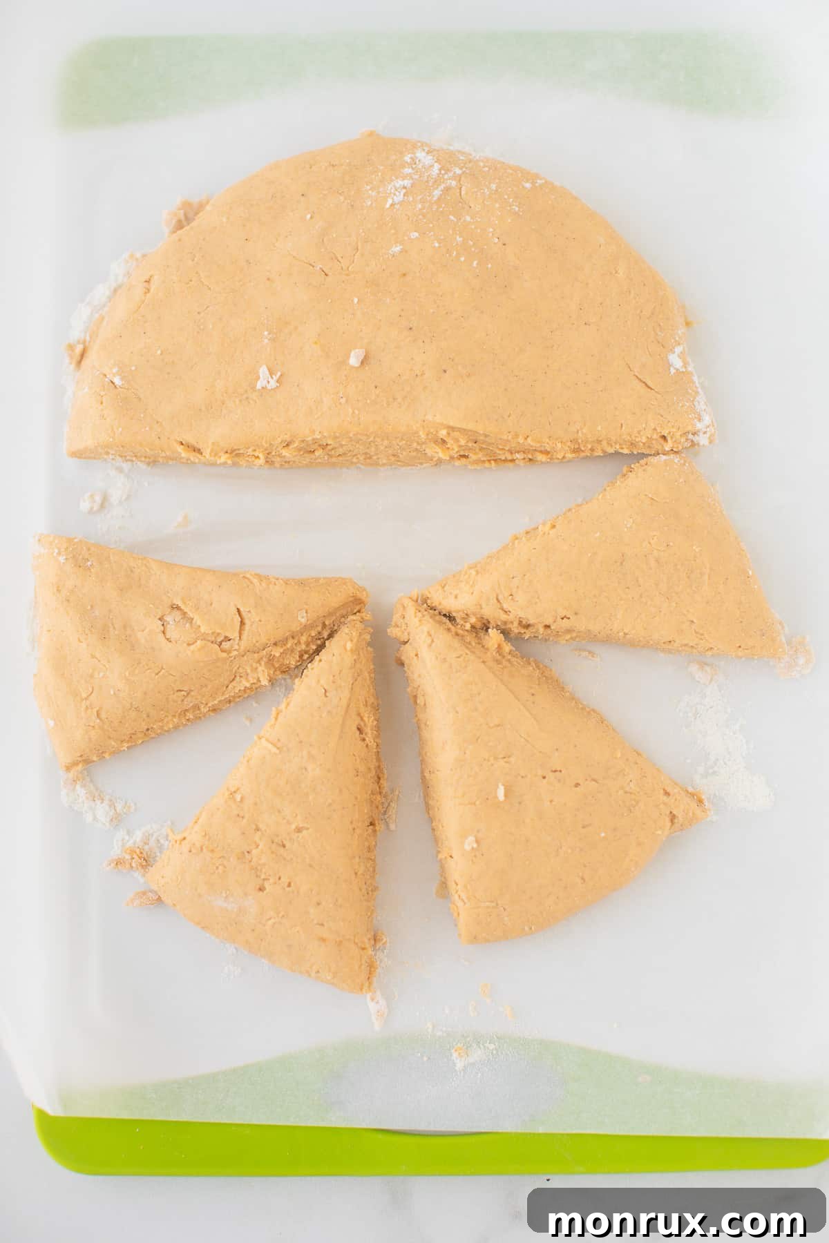 Scone dough, perfectly formed into a circular disc, resting on a cutting board, ready for cutting.