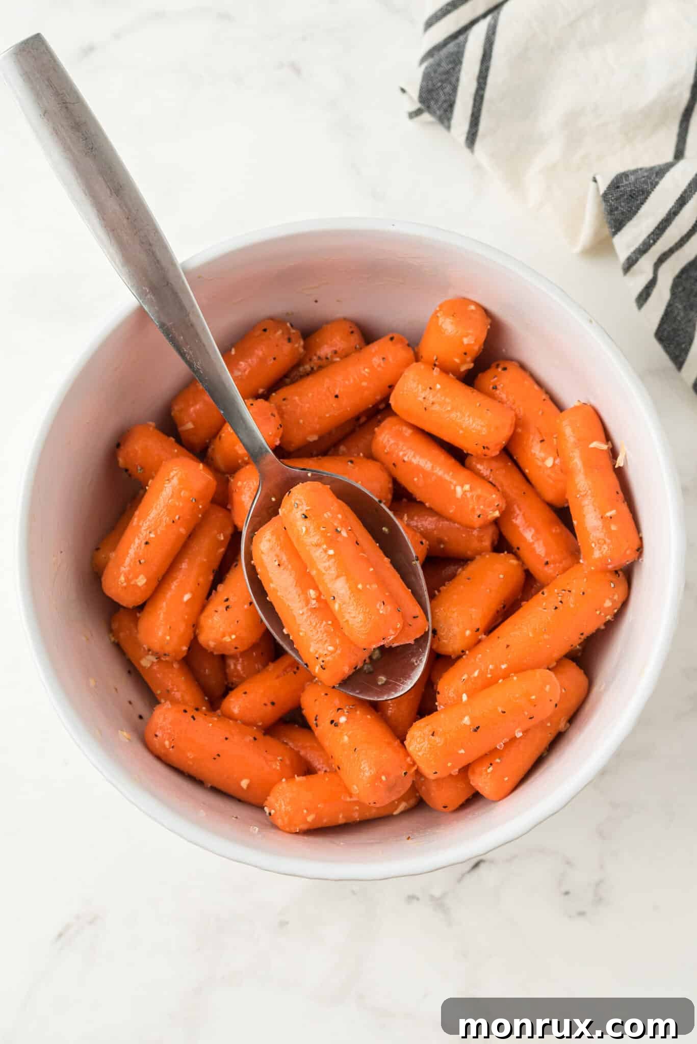 Seasoned baby carrots evenly coated and ready for the air fryer.