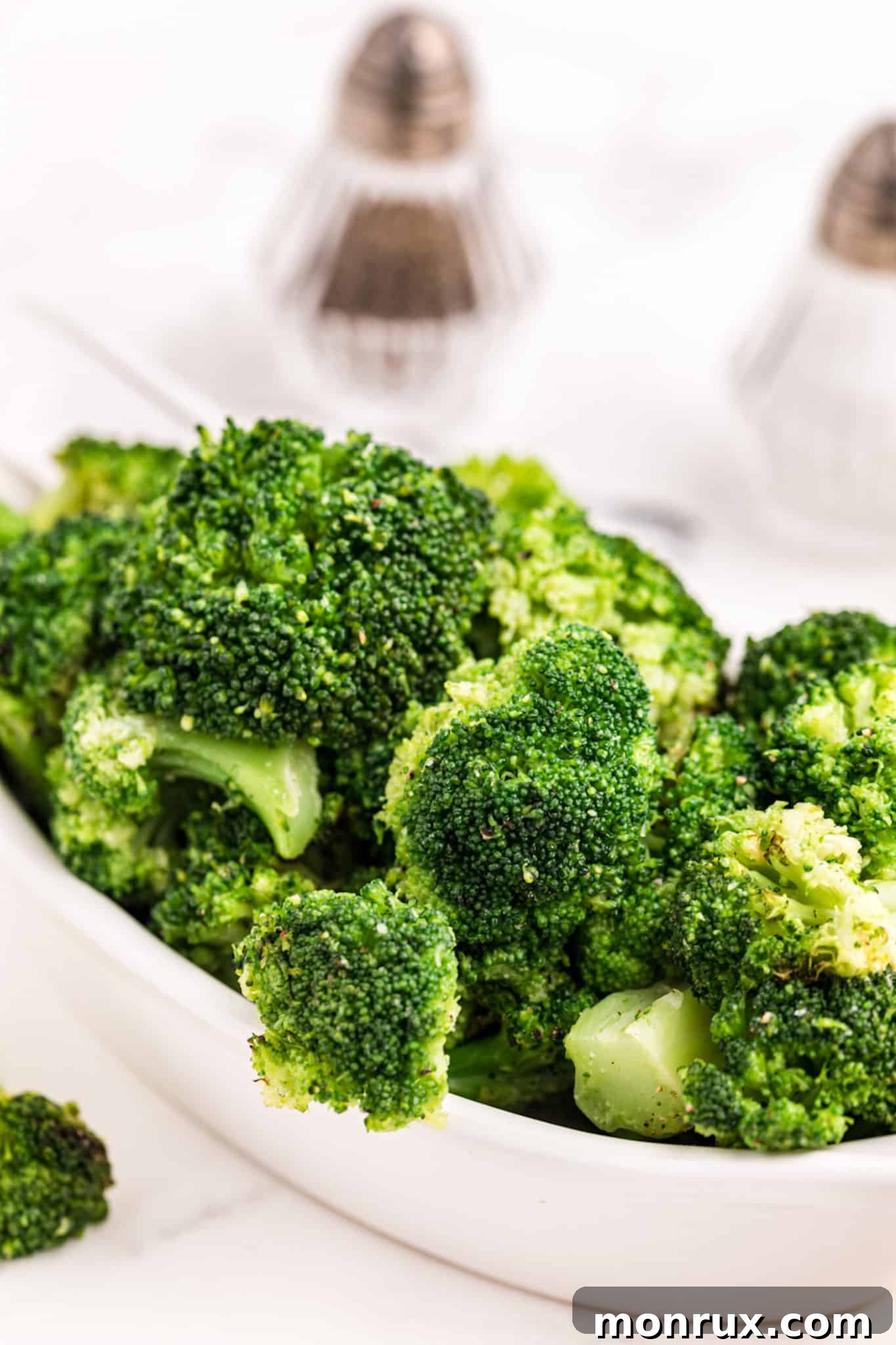 A large bowl of vibrant green, steamed broccoli, beautifully prepared.