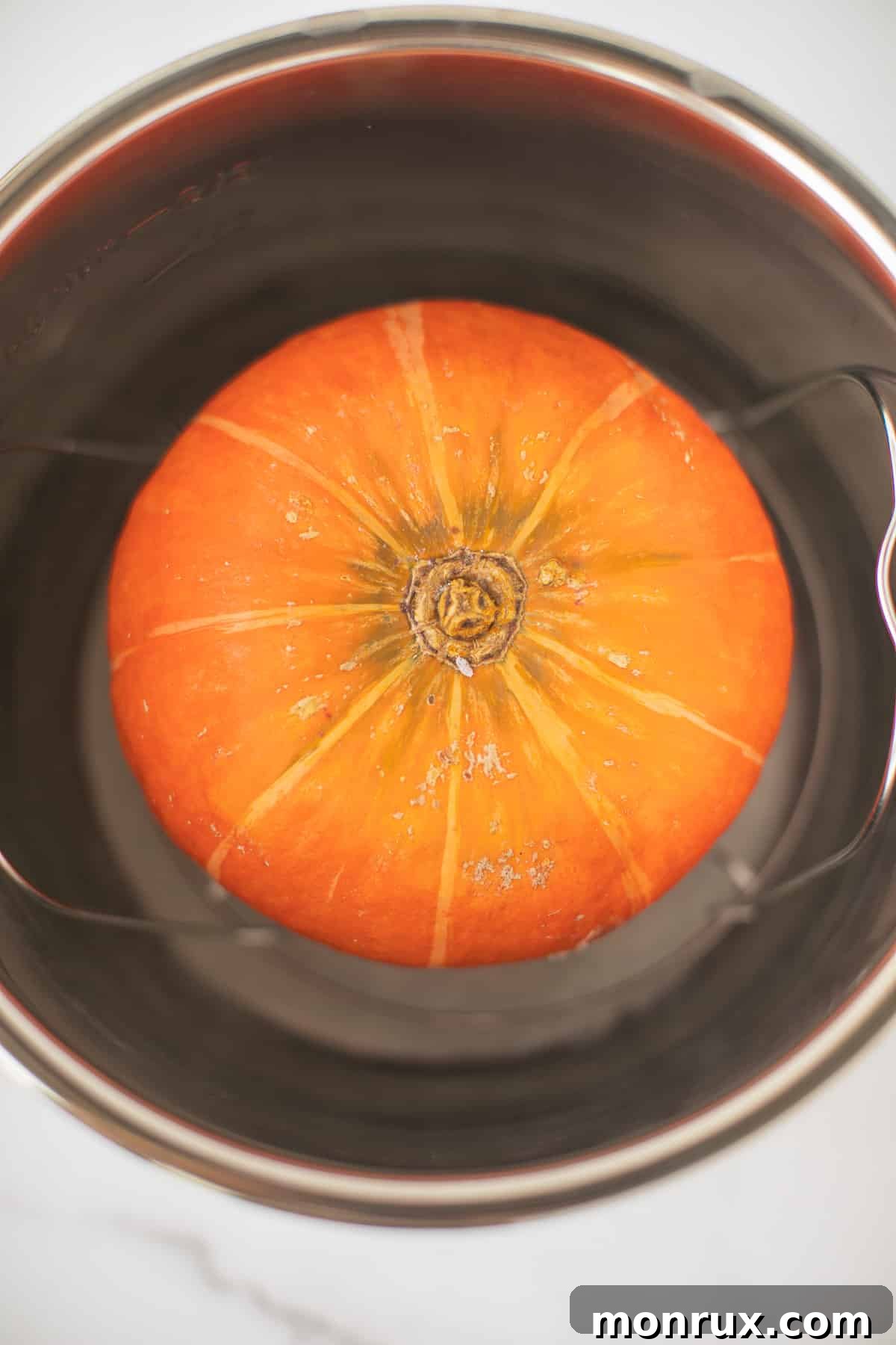 Vibrant orange kabocha squash nestled inside an Instant Pot, ready for pressure cooking.