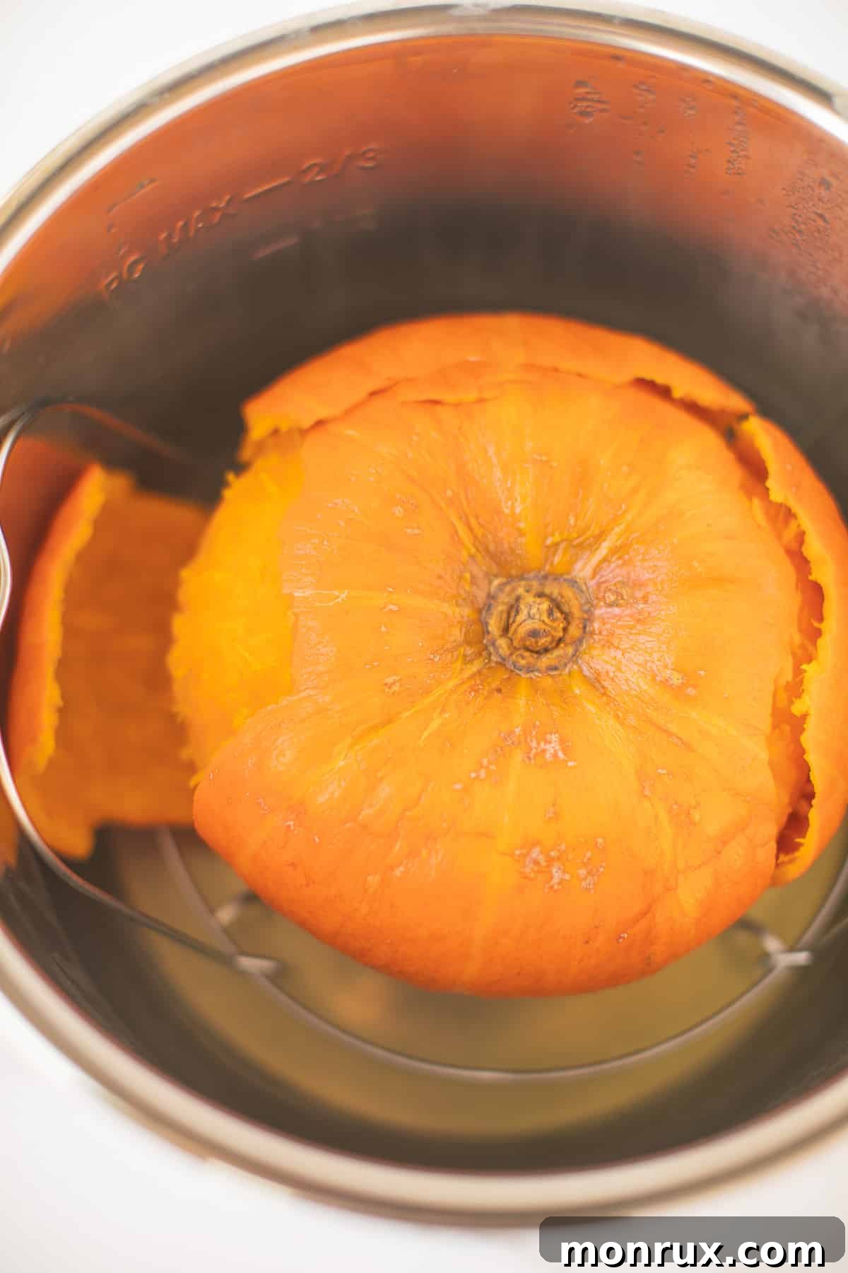 Perfectly cooked kabocha squash, halved and tender, resting inside an Instant Pot.
