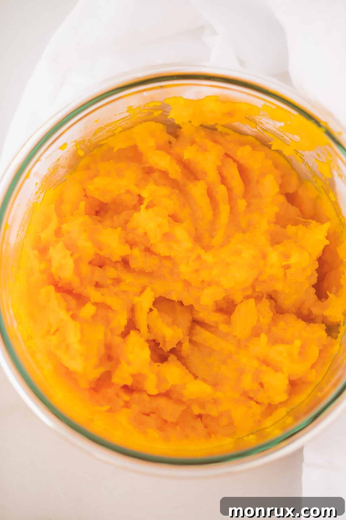 Creamy kabocha squash puree presented beautifully in a clear glass bowl, ready to be savored.