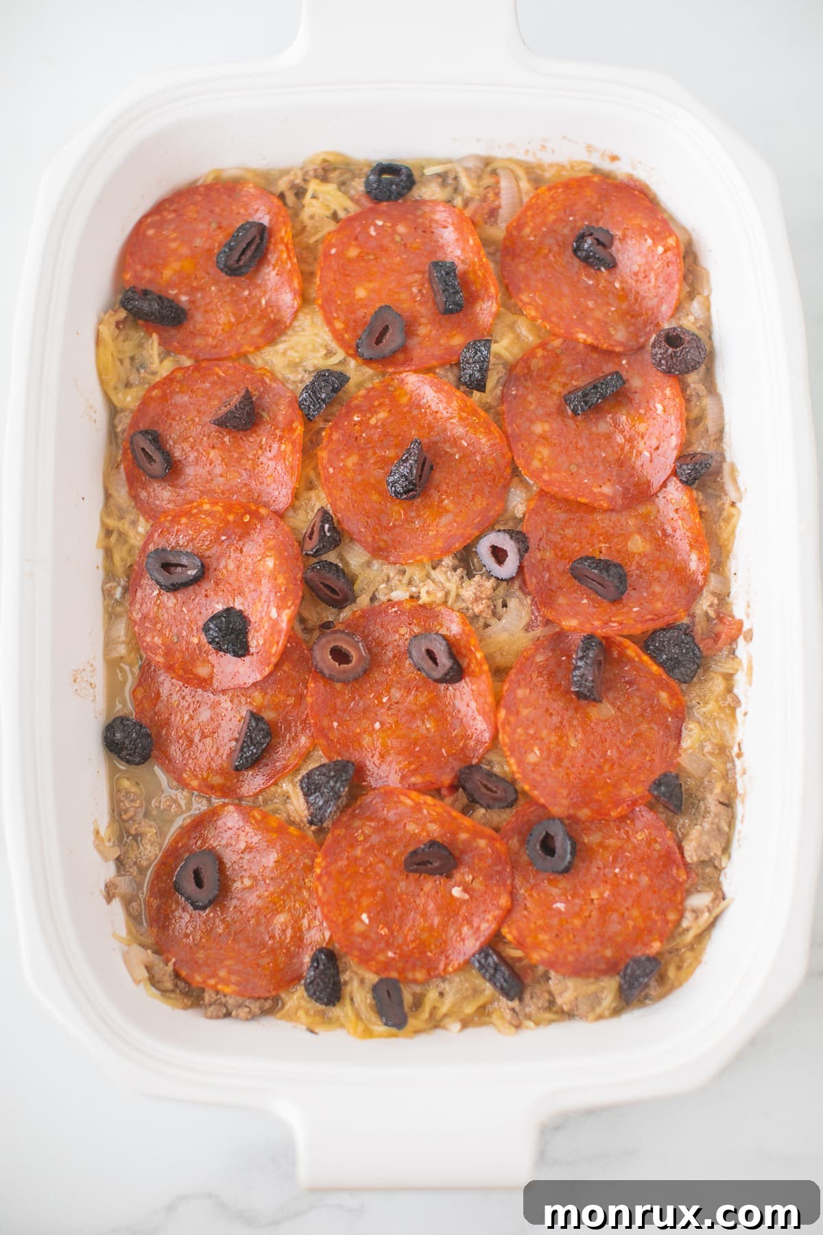 cooked spaghetti squash casserole in a white baking dish, fresh from the oven