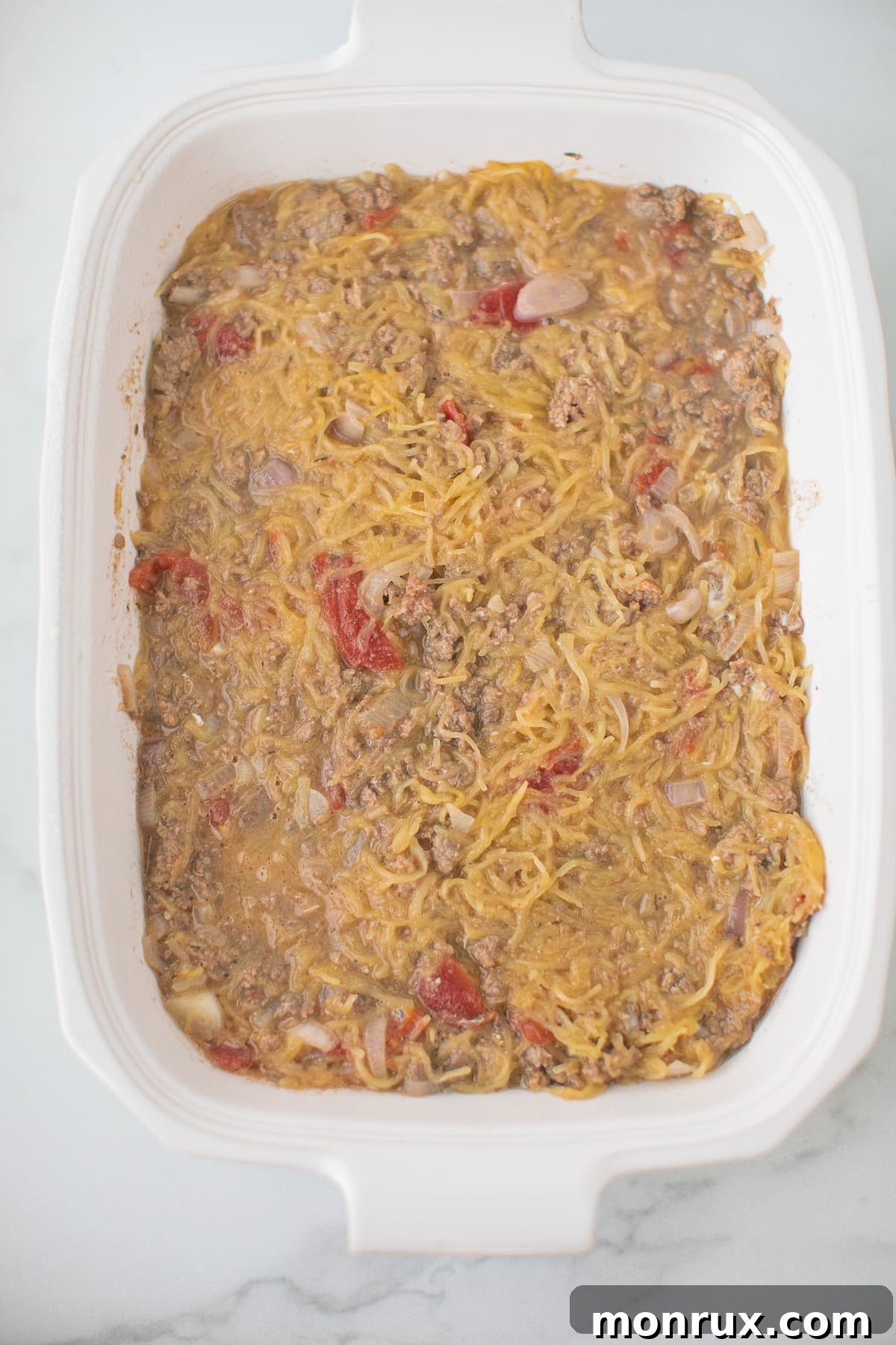spaghetti squash casserole process shot with ingredients mixed in baking dish