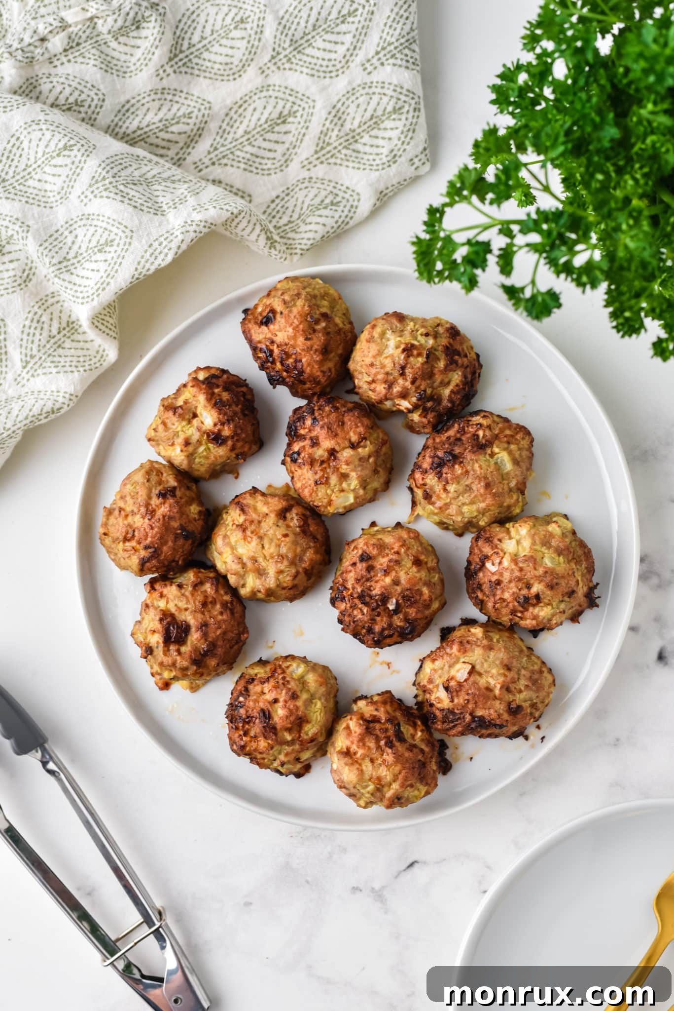 A plate of cooked air fried turkey meatballs, perfectly browned and ready to eat.