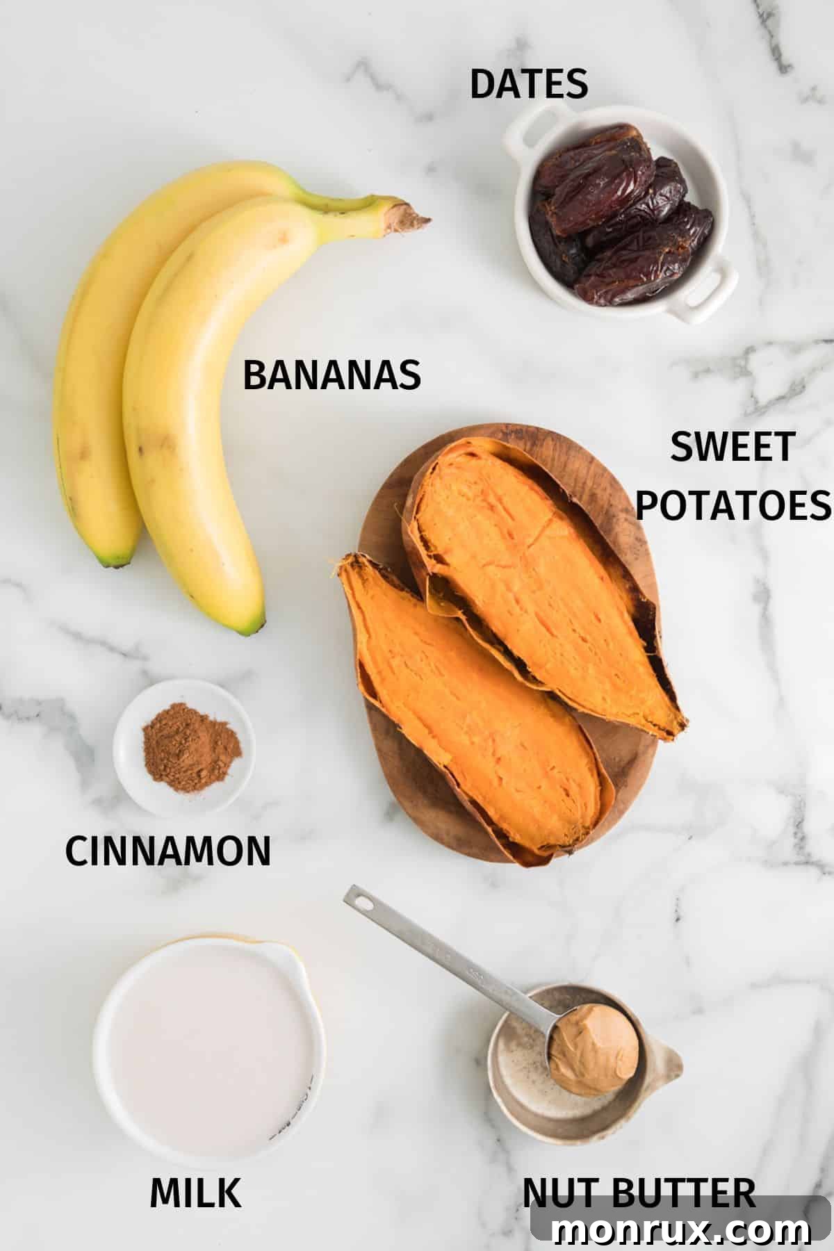 Ingredients for a sweet potato smoothie laid out in small bowls on a white surface, including cooked sweet potato, plant milk, frozen banana, dates, cinnamon, and seed butter.