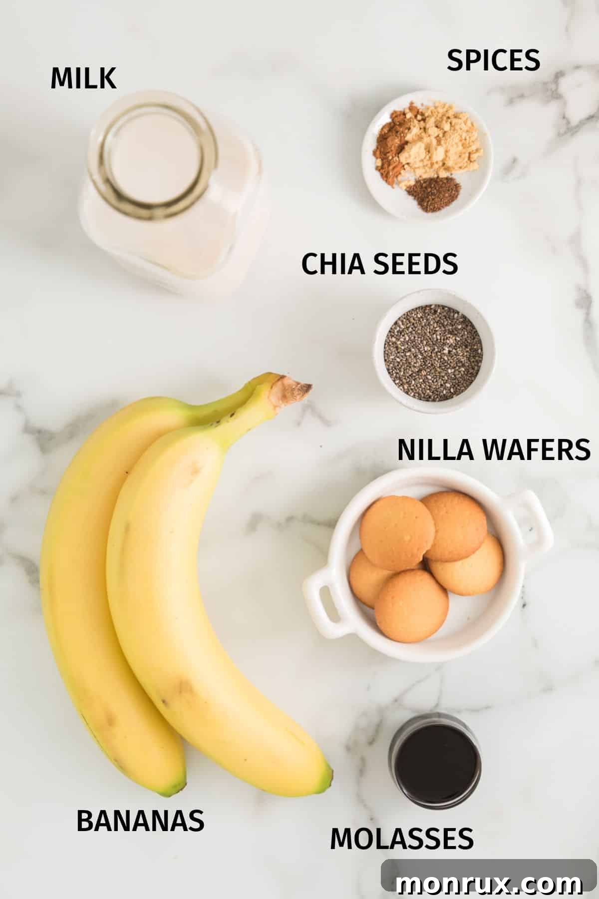 Ingredients to make a gingerbread smoothie in small bowls on a white surface, showcasing fresh and natural elements.