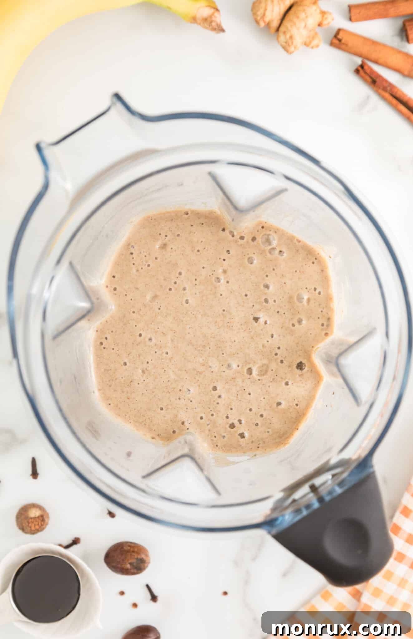Gingerbread smoothie expertly blended and swirling in the jar of a high-powered blender, ready for serving.