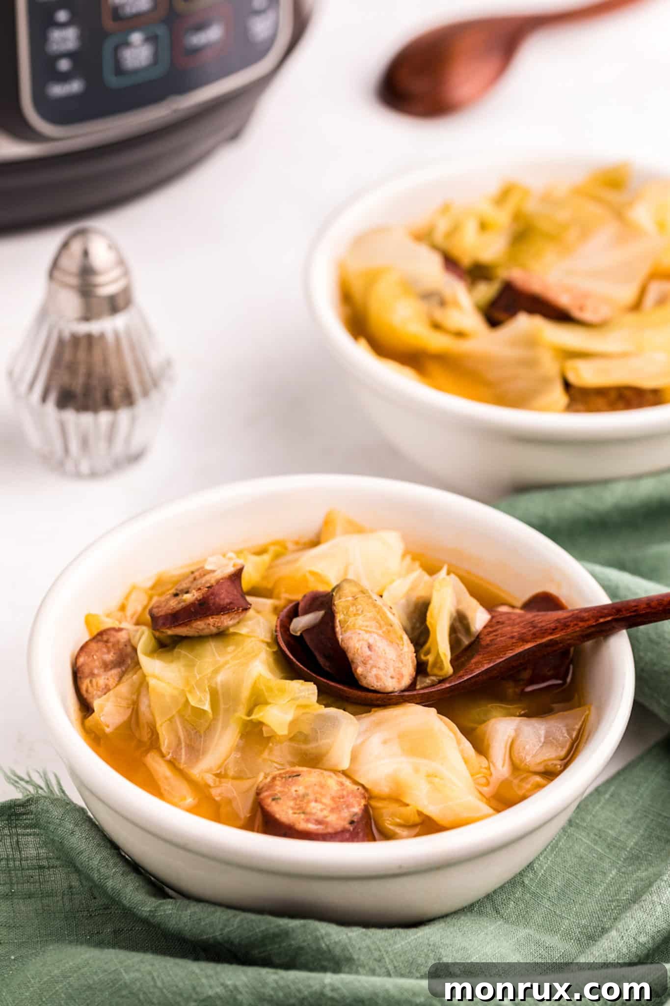 instant pot cabbage soup with sausage served in white bowl.