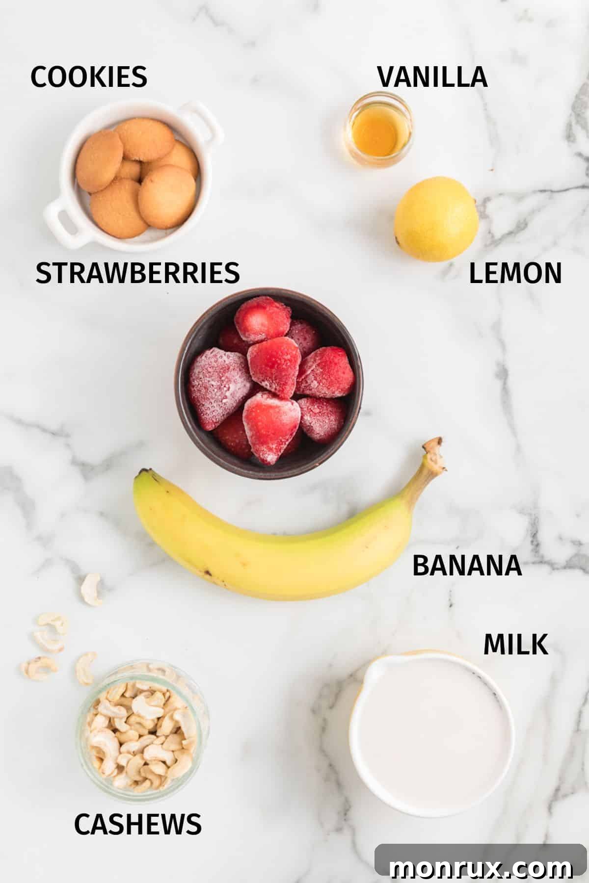 A vibrant selection of ingredients laid out on a clean white surface, ready to be transformed into a delicious Strawberry Cheesecake Smoothie.
