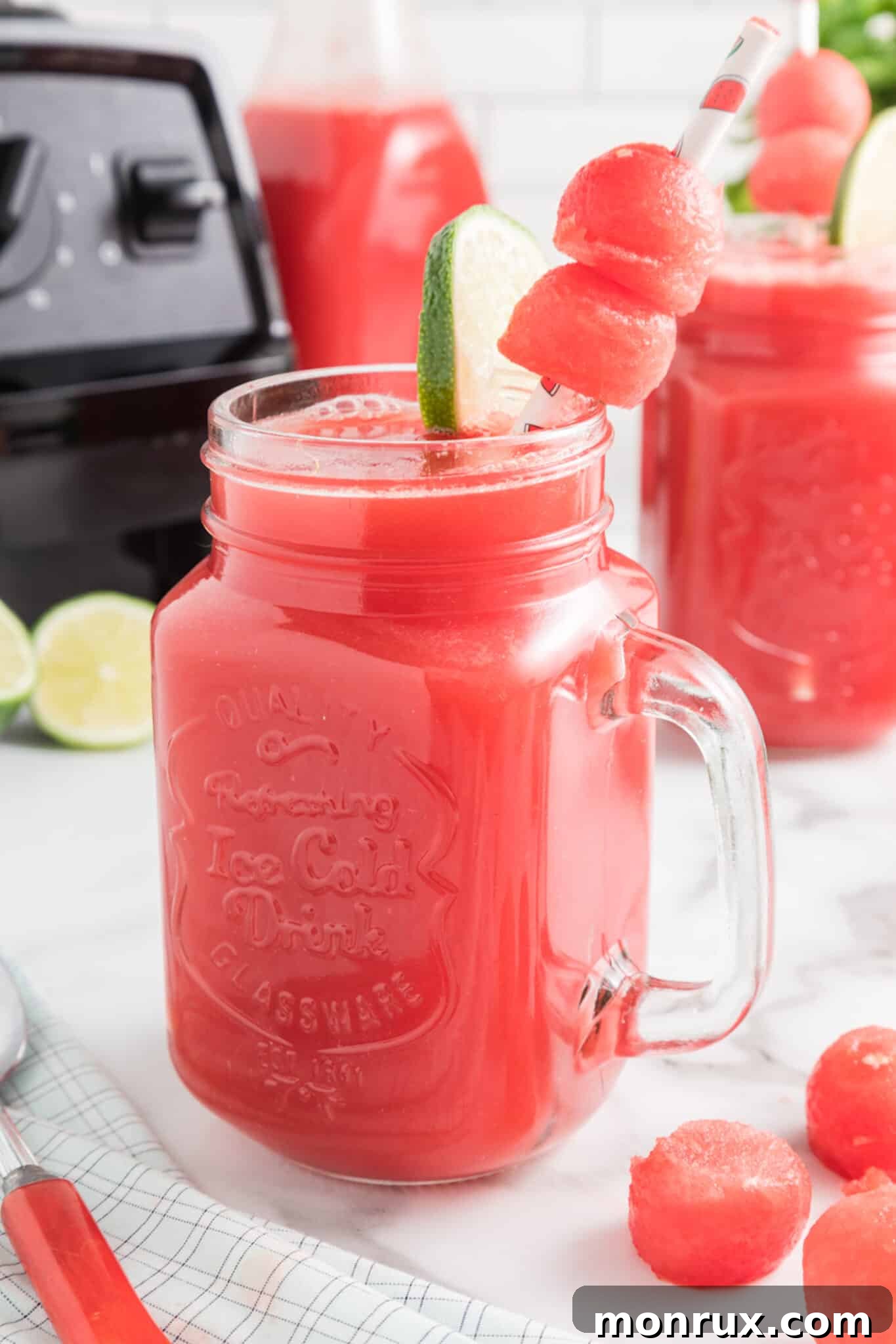 A vibrant glass of Watermelon Mint Juice, garnished with a lime slice and fresh mint leaves.