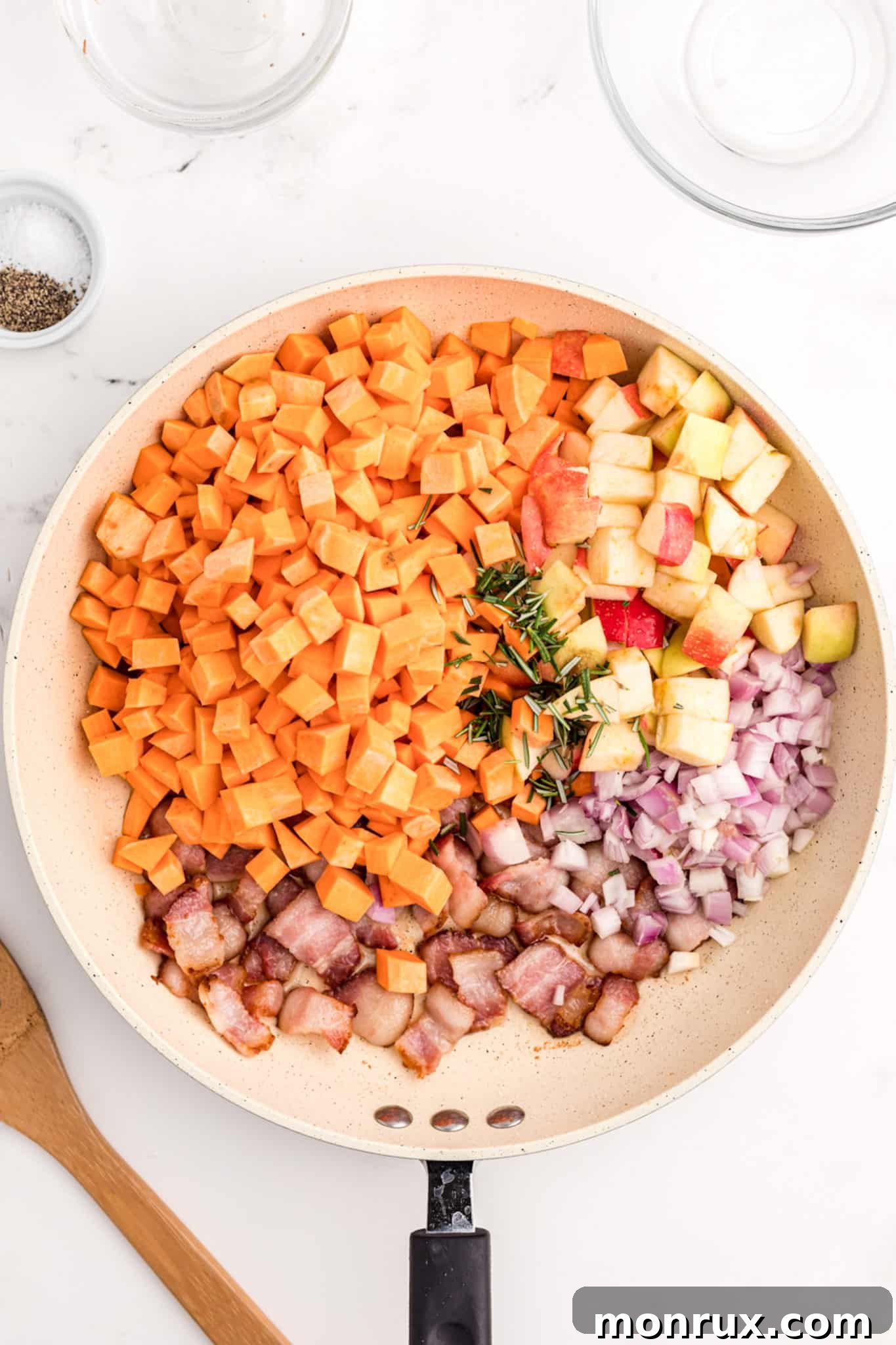 A large cast-iron skillet on a stovetop, filled with the vibrant Sweet Potato Apple Hash mixture, actively cooking and steaming, showcasing the beautiful colors of the ingredients.