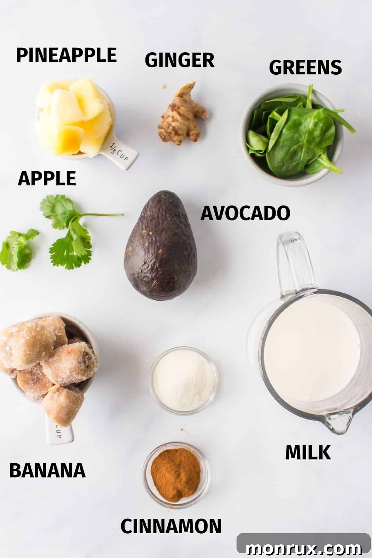 Fresh ingredients laid out for making a liver detox smoothie: plant milk, avocado, cilantro, spinach, ginger, banana, and pineapple.