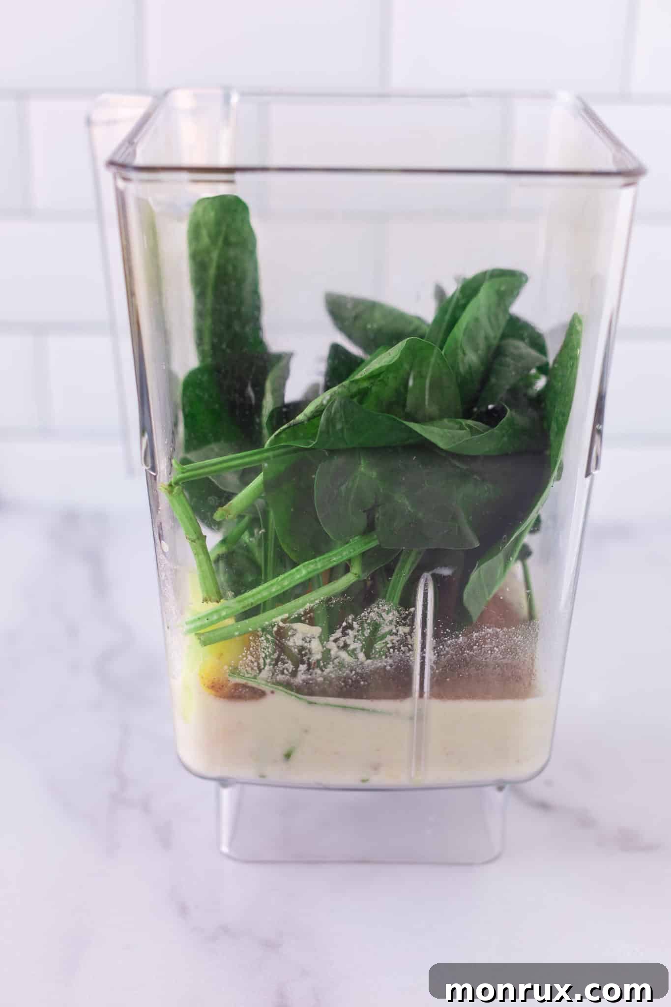 All ingredients for the detox smoothie placed inside a high-speed blender container, ready to be blended.
