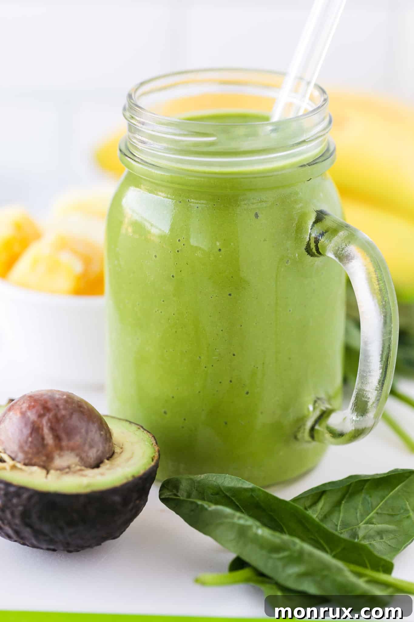 A vibrant green liver detox smoothie served in a clear glass with a glass straw, indicating a healthy, refreshing drink.