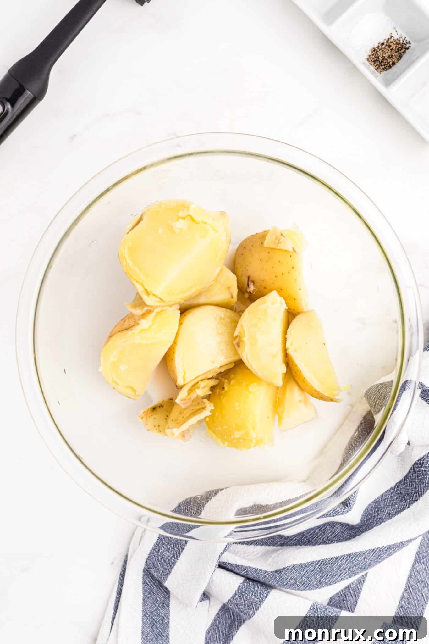 Cooked white potatoes in a mixing bowl, ready for mashing.