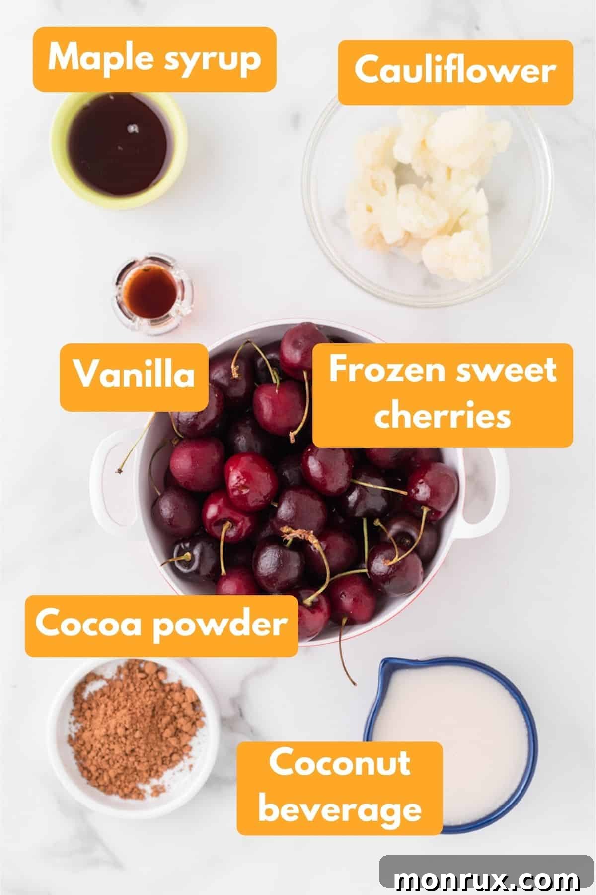 A selection of ingredients for a chocolate cherry smoothie, including frozen cherries, cocoa, and coconut beverage.