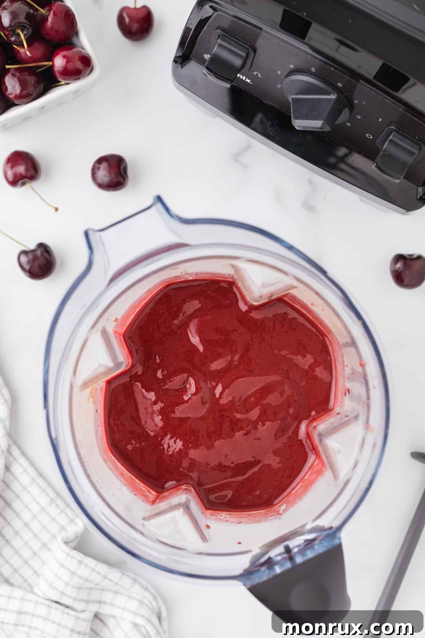 A vibrant cherry smoothie being blended to a perfect, smooth consistency.