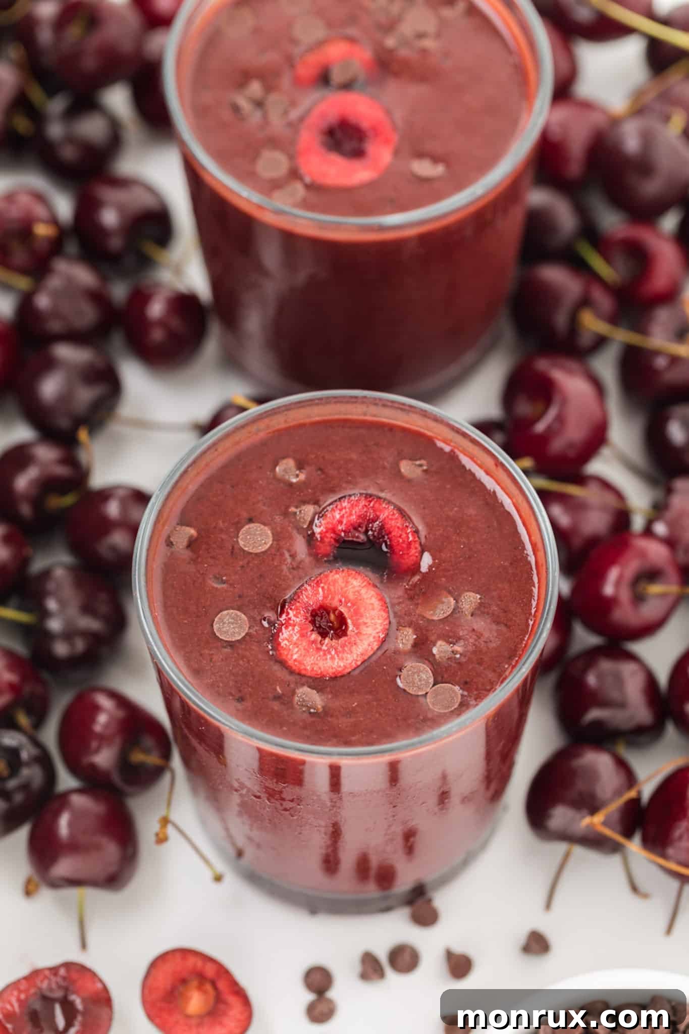 Thick chocolate cherry smoothies served in elegant glasses, surrounded by fresh cherries.