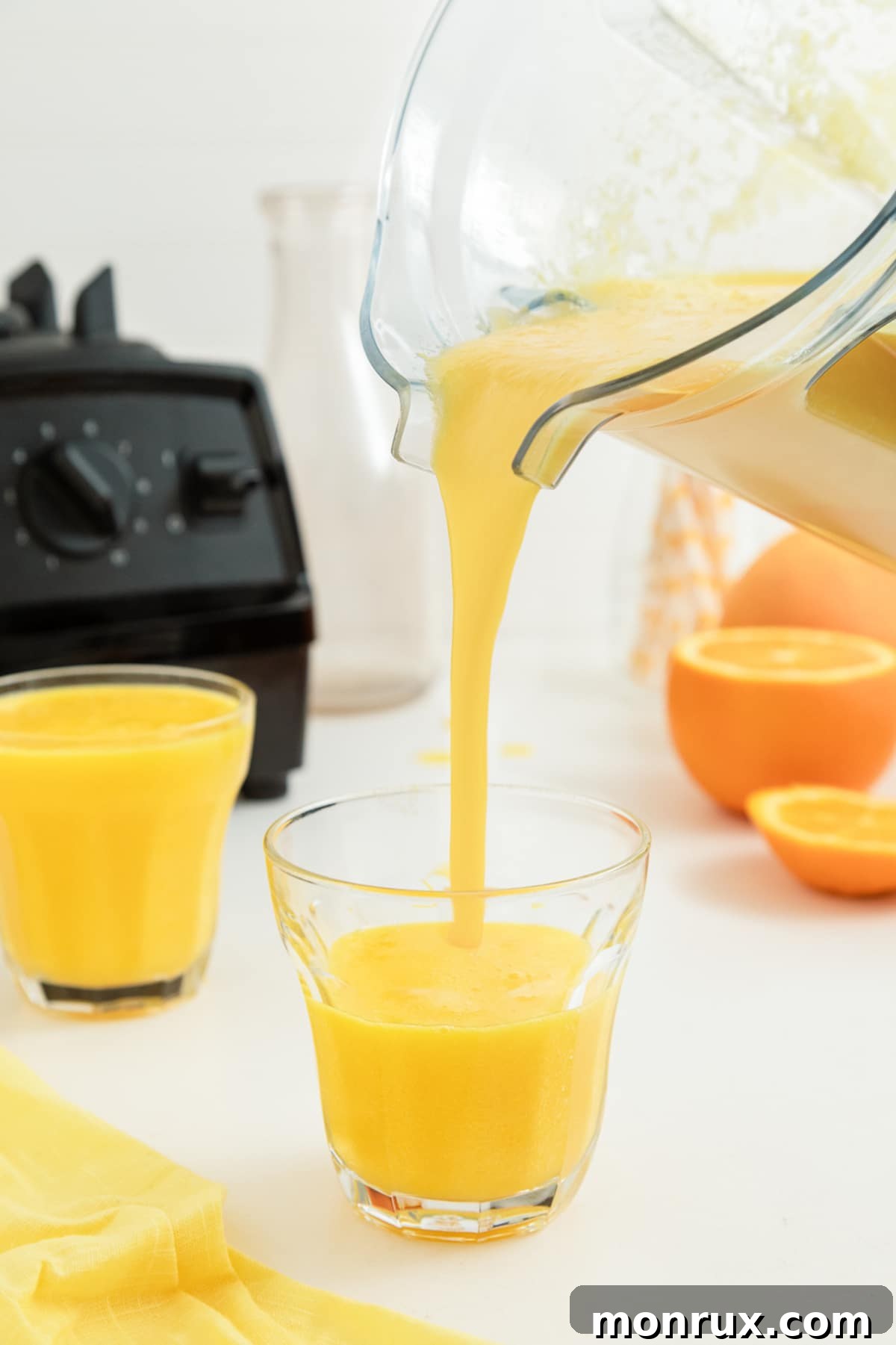pouring orange juice from vitamix into glass.