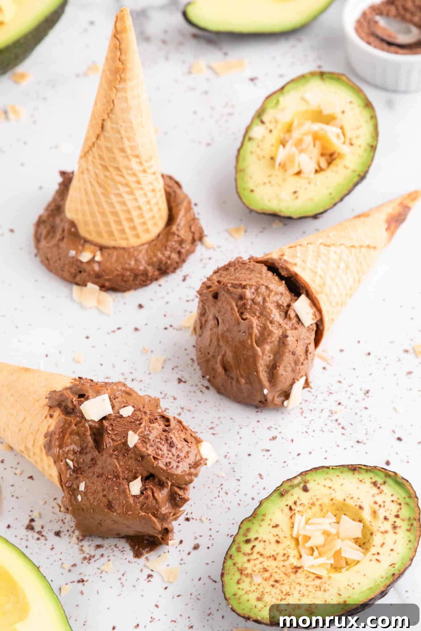 Three sugar cones on their sides filled with avocado chocolate ice cream, garnished with chocolate shavings.