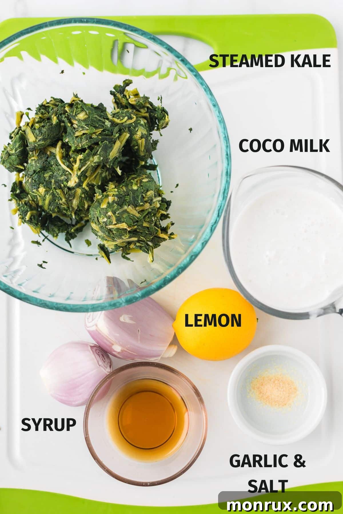 Individual ingredients neatly laid out for the vegan creamed kale recipe, including frozen kale, coconut milk, onion, and lemon.