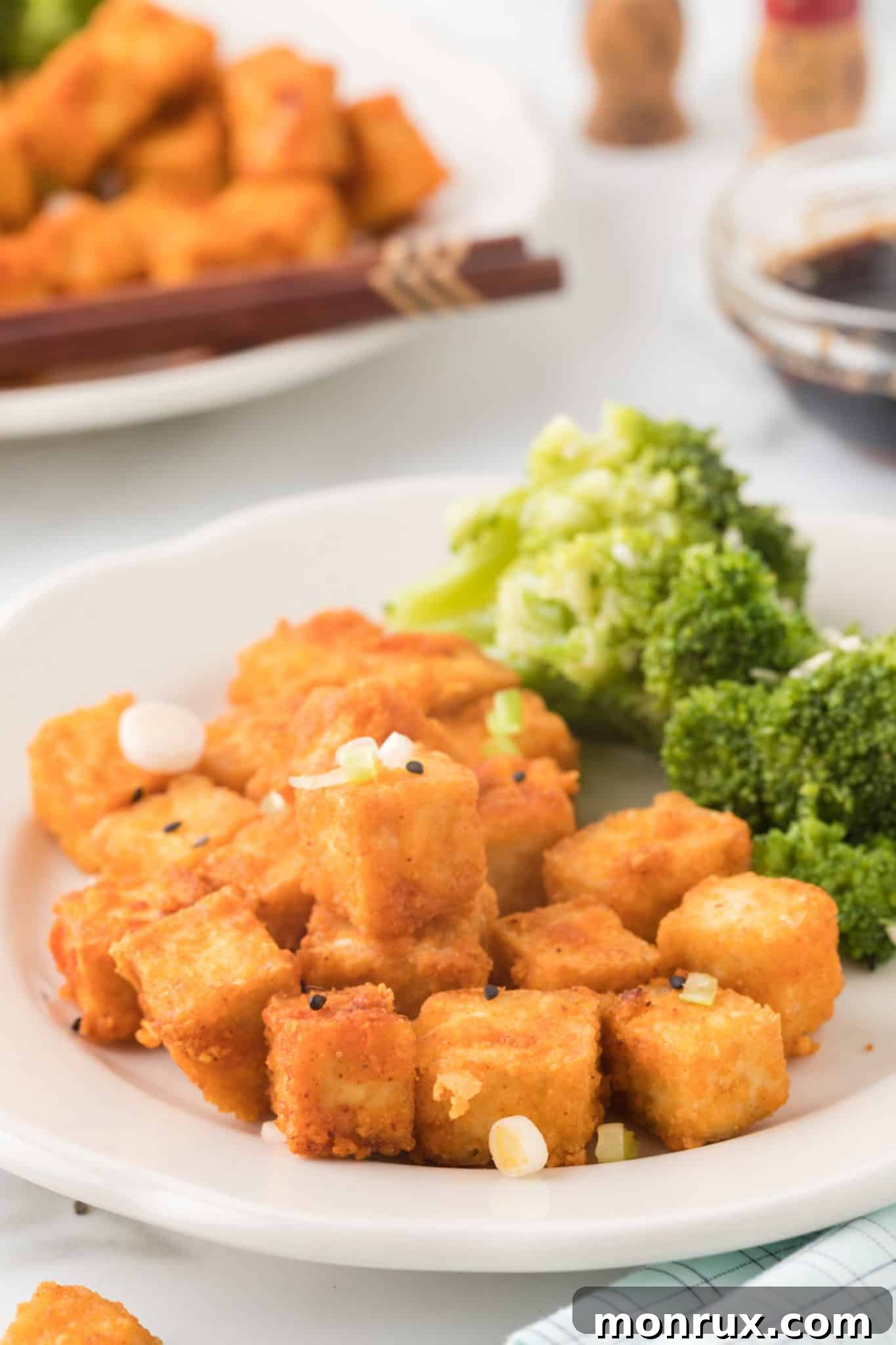 Crispy air fryer tofu served with vibrant green broccoli, highlighting its golden texture.