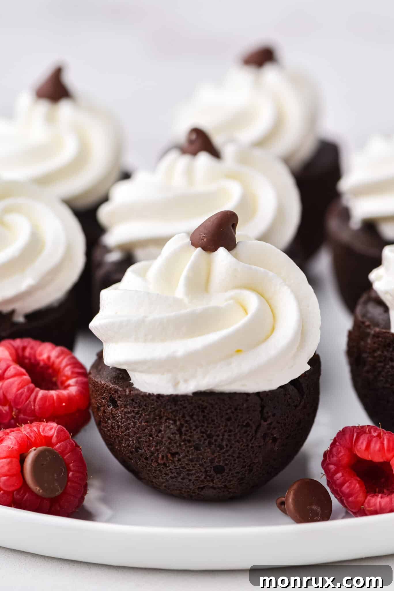 Instant Pot brownie bites topped with whipped cream on a white plate, ready to be served as a delicious dessert.