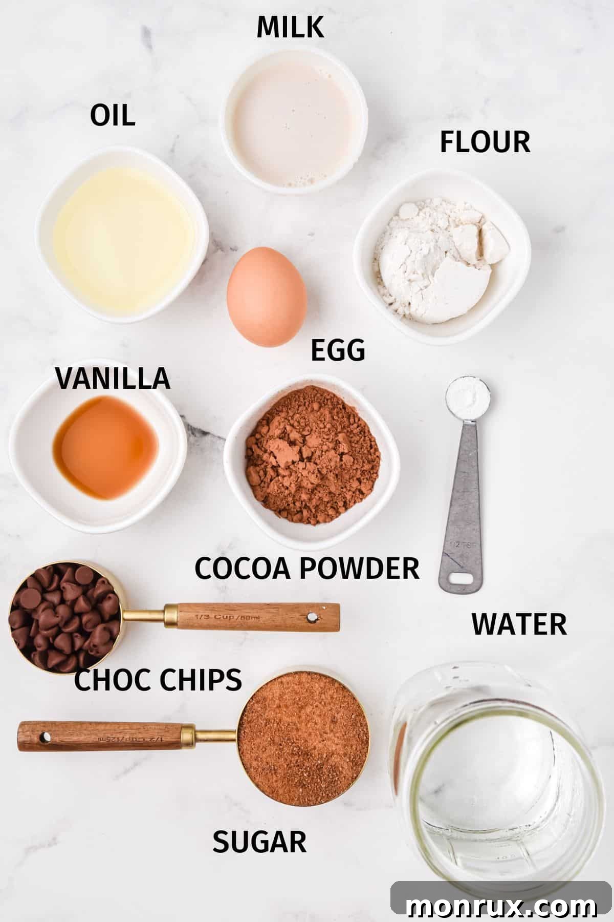 A selection of key ingredients laid out for making instant pot brownie bites, including flour, cocoa, chocolate chips, and eggs.