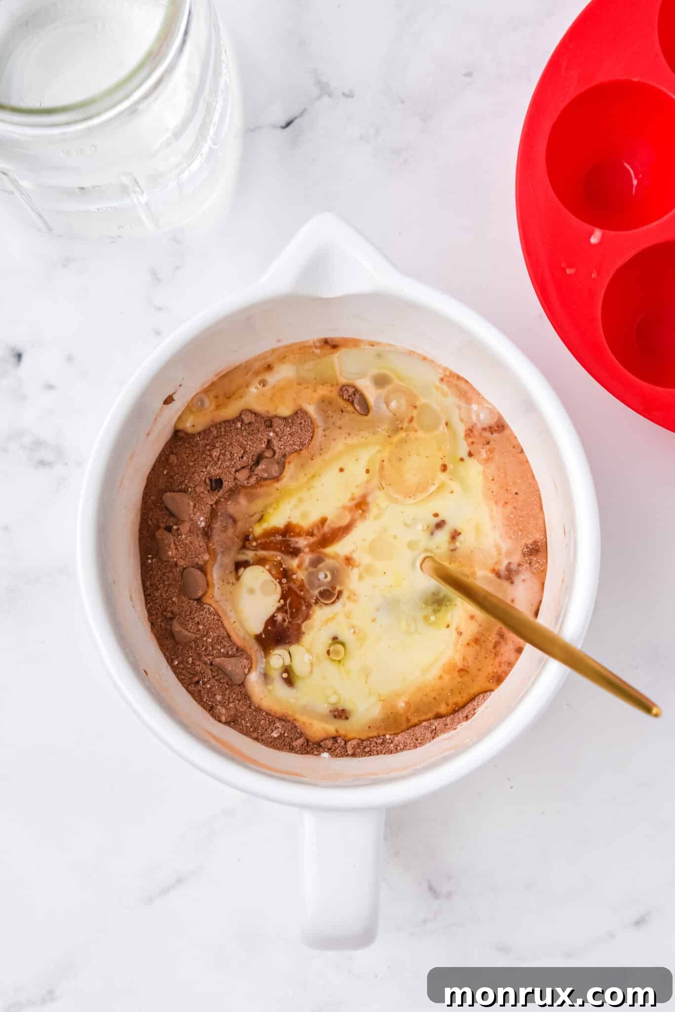 Wet and dry ingredients for instant pot brownie bites partially combined in a bowl.