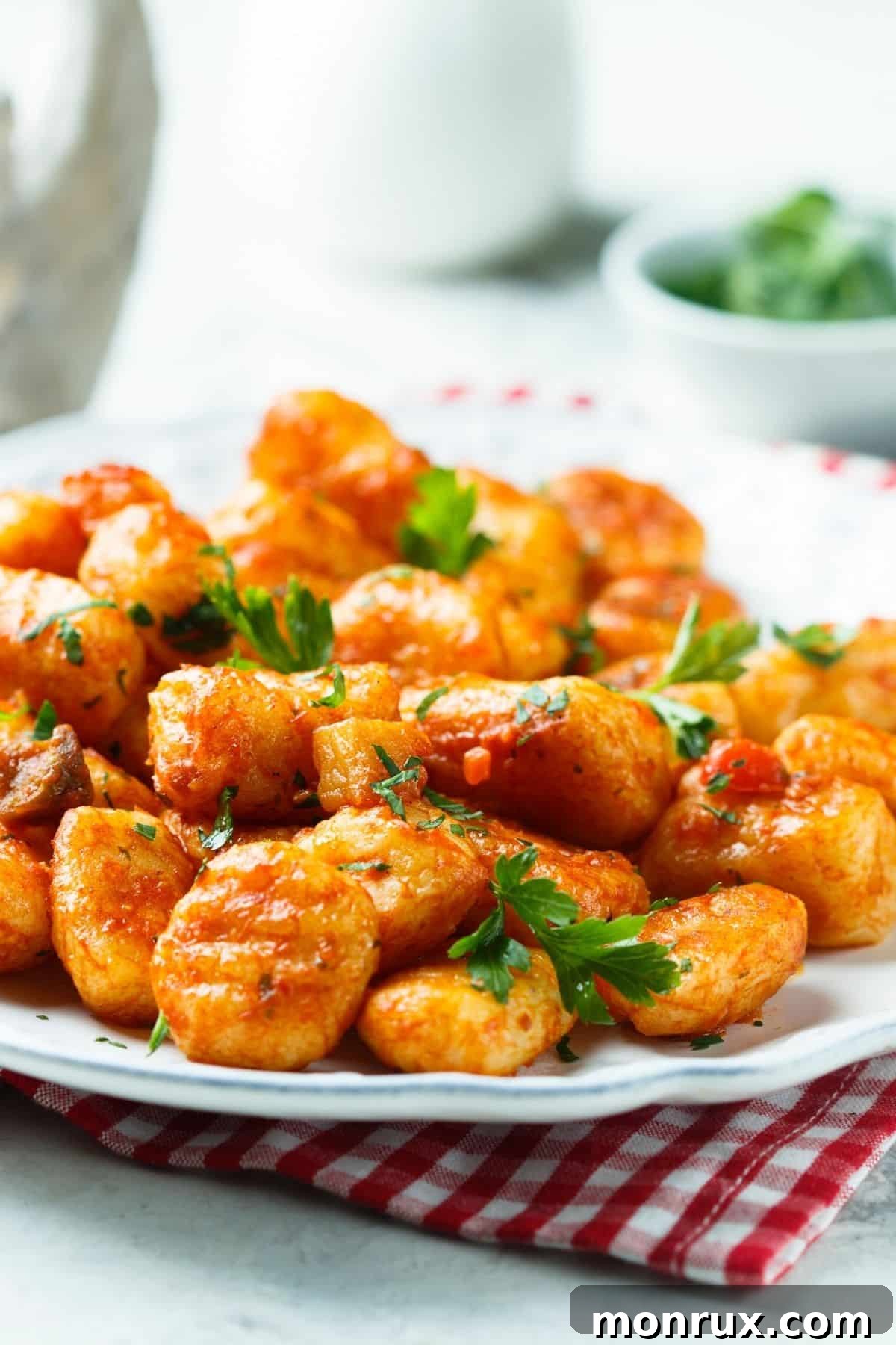 A beautifully plated dish of homemade Gluten-Free Vegan Gnocchi, generously coated in rich marinara sauce, garnished with fresh basil. This comforting Italian classic is entirely plant-based and gluten-free.