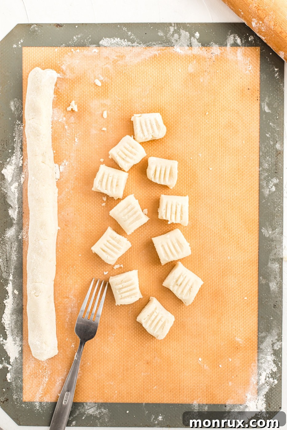 Freshly cut and shaped gluten-free gnocchi pieces, each with the classic fork indentation, ready for cooking.