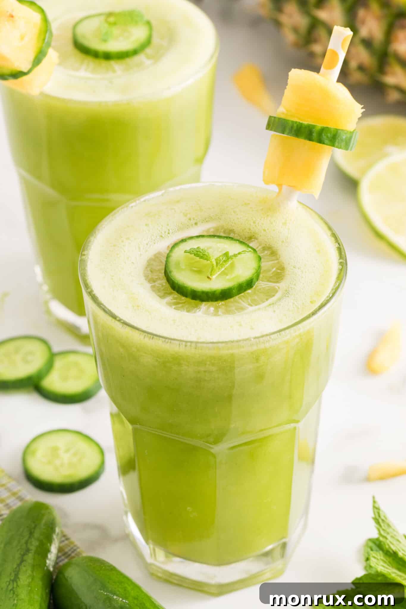 A vibrant cucumber pineapple smoothie, garnished with a fresh cucumber slice, ready to be enjoyed.