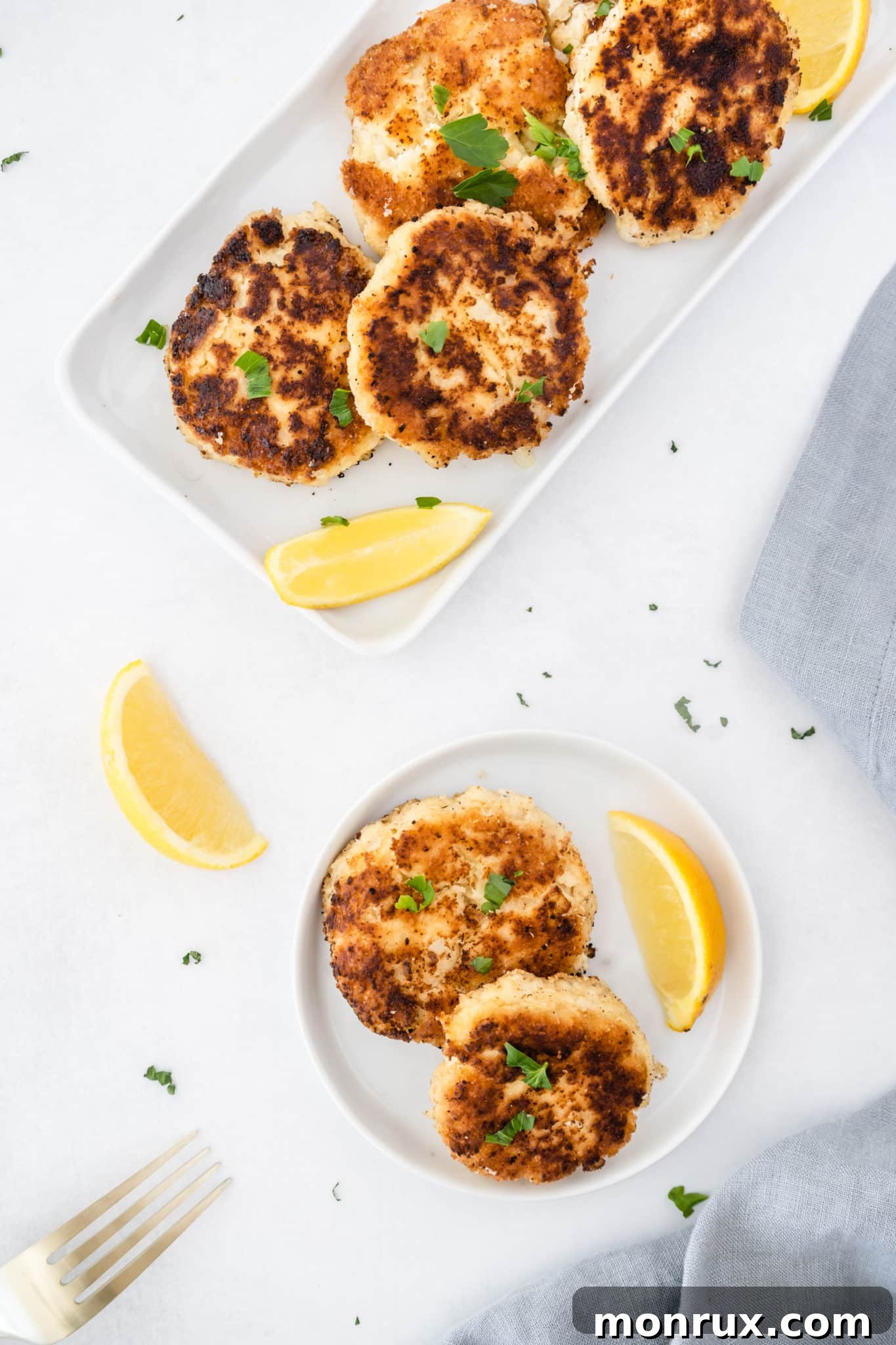 Gluten-free, low-carb, and keto crab cakes served with fresh parsley and lemon slices on a white plate.