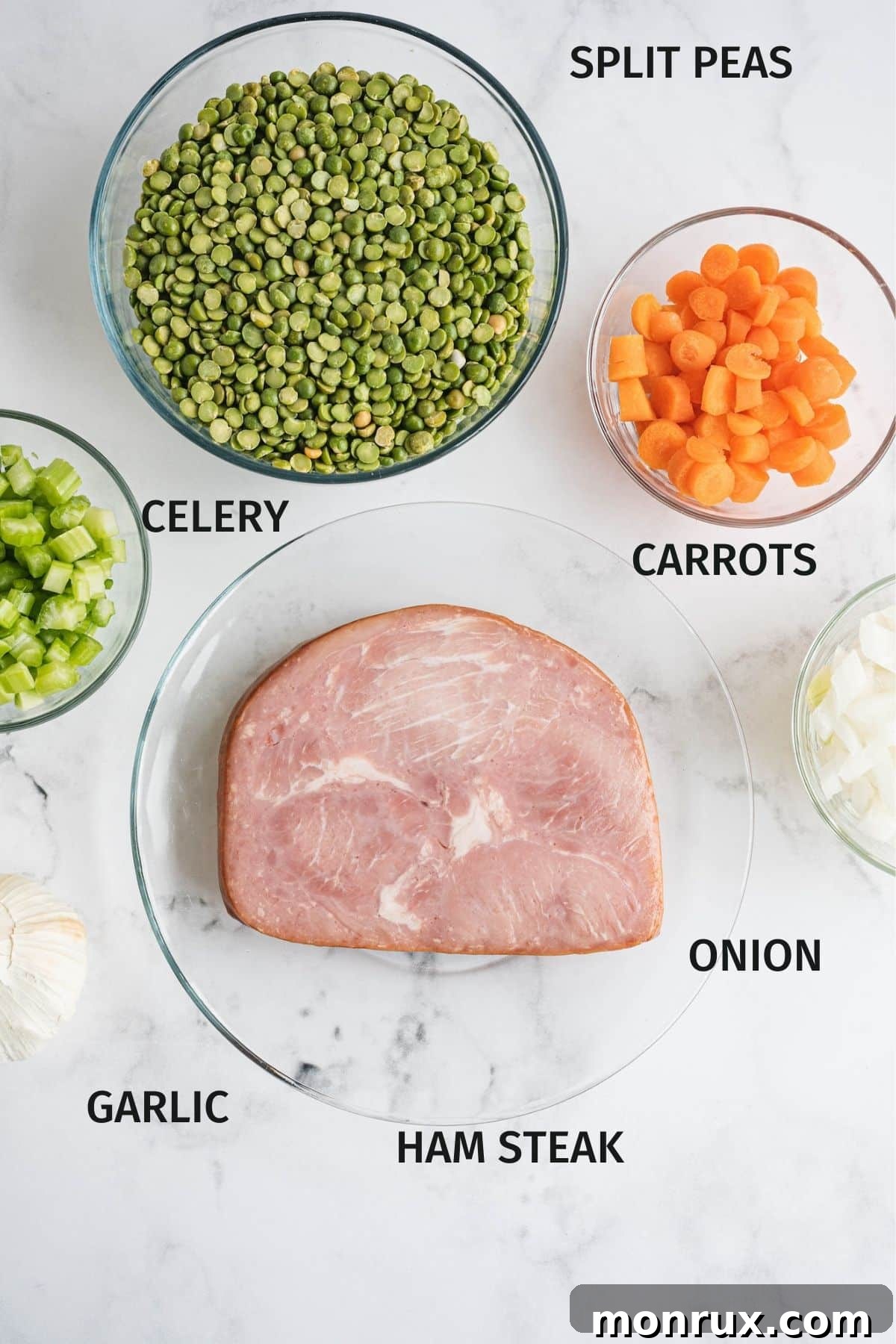 A vibrant selection of fresh ingredients laid out for Instant Pot Split Pea and Ham Soup, including carrots, celery, onion, garlic, split peas, and ham.