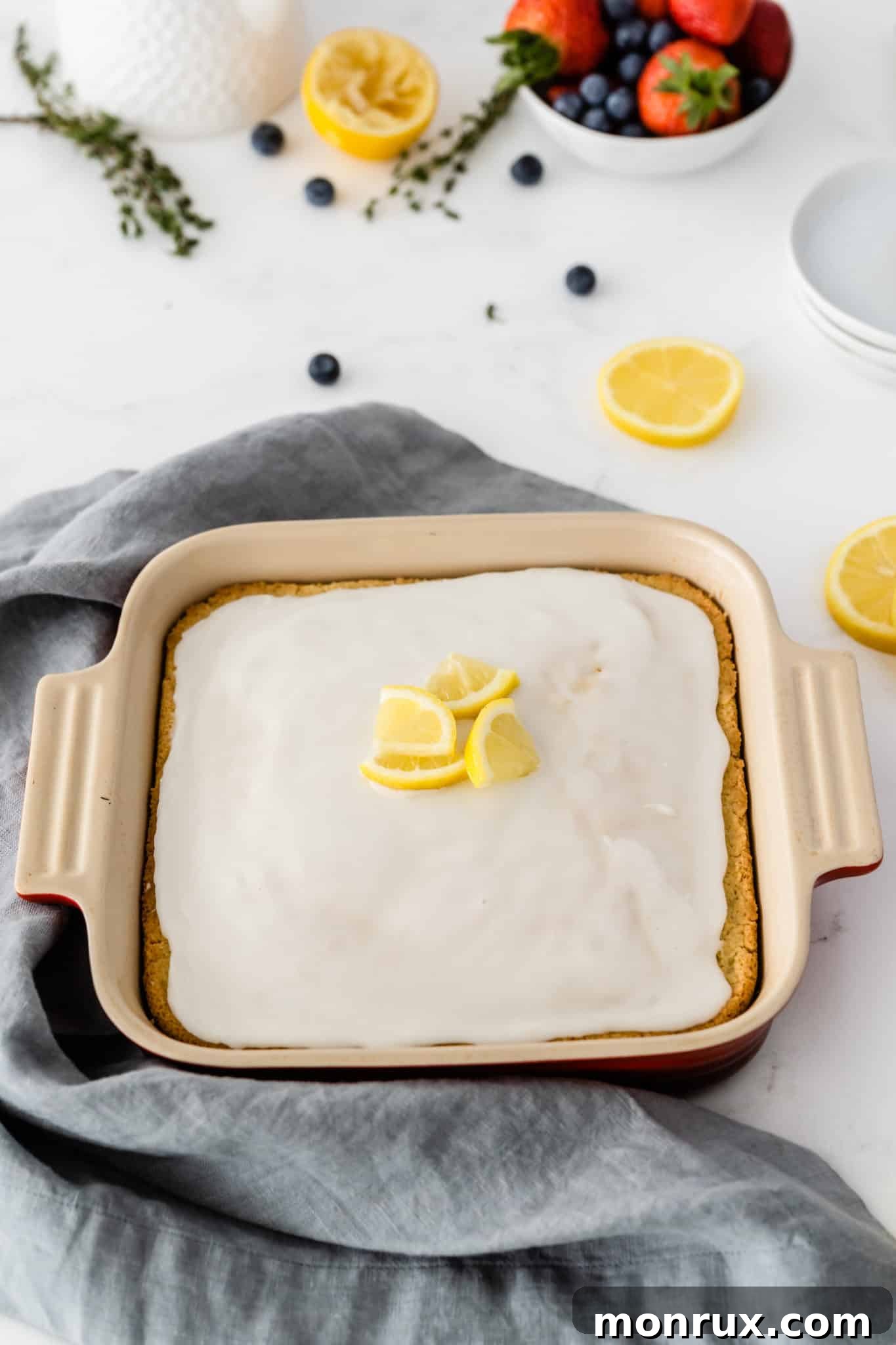 A freshly baked lemon cake with a rich lemon icing drizzle, ready to be cut and served.