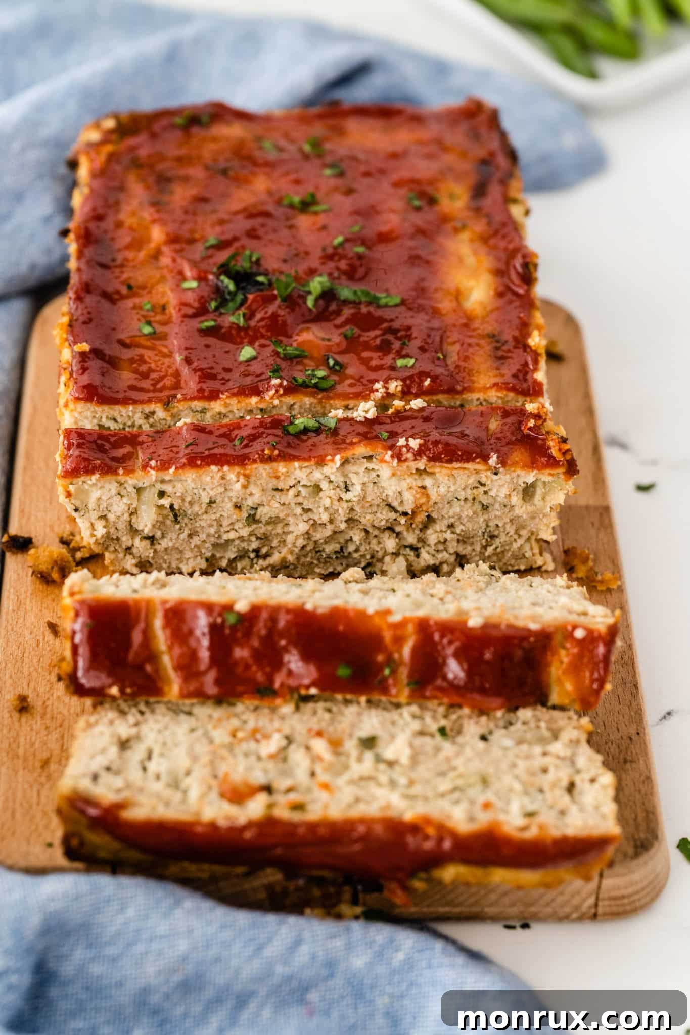 Sliced chicken meatloaf with a generous layer of sugar-free ketchup on top, ready to serve.