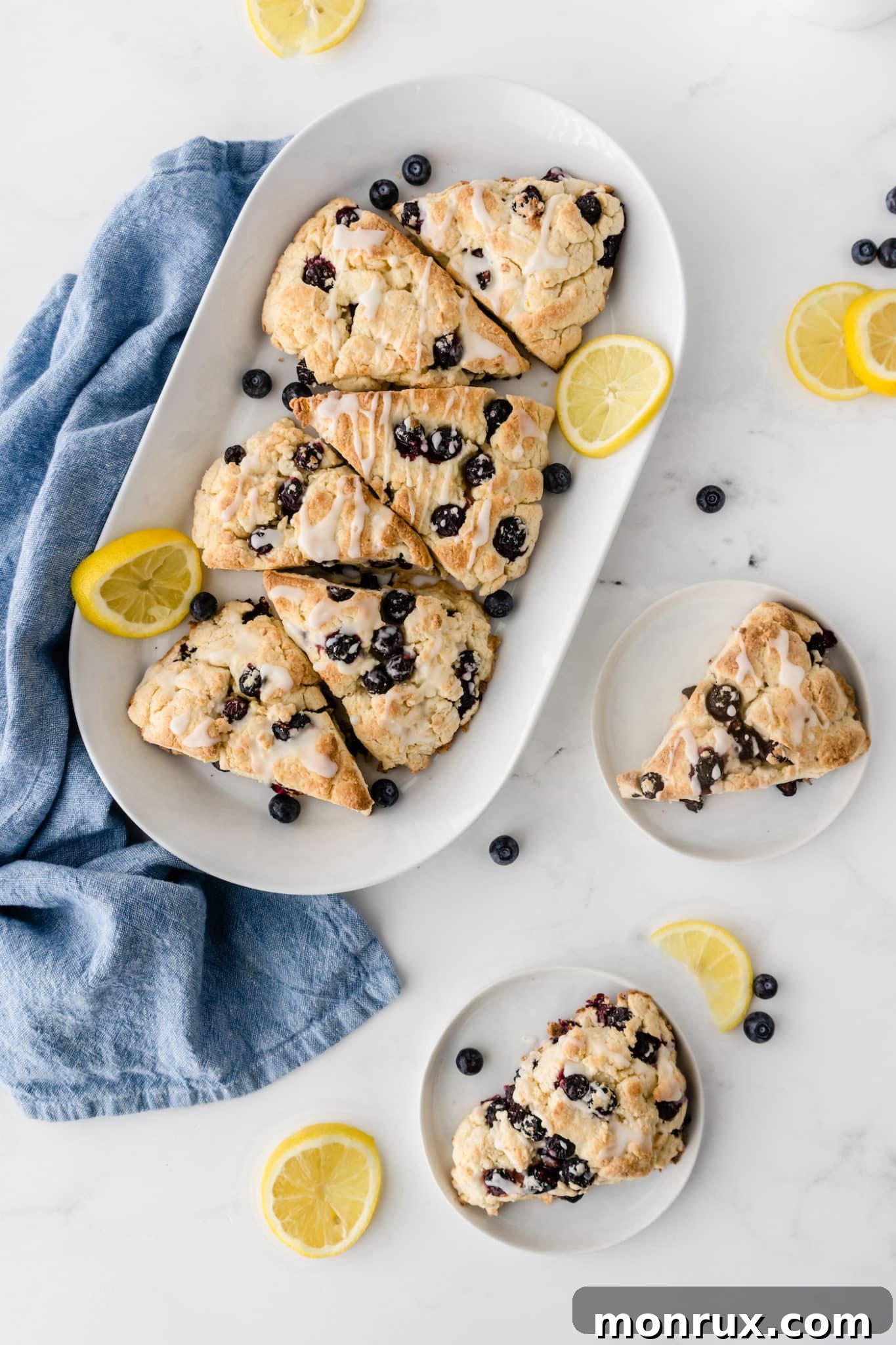 A vibrant platter of freshly baked gluten-free blueberry scones, each perfectly golden with juicy blueberries peeking through, beautifully arranged with fresh lemon slices, ready to be enjoyed.