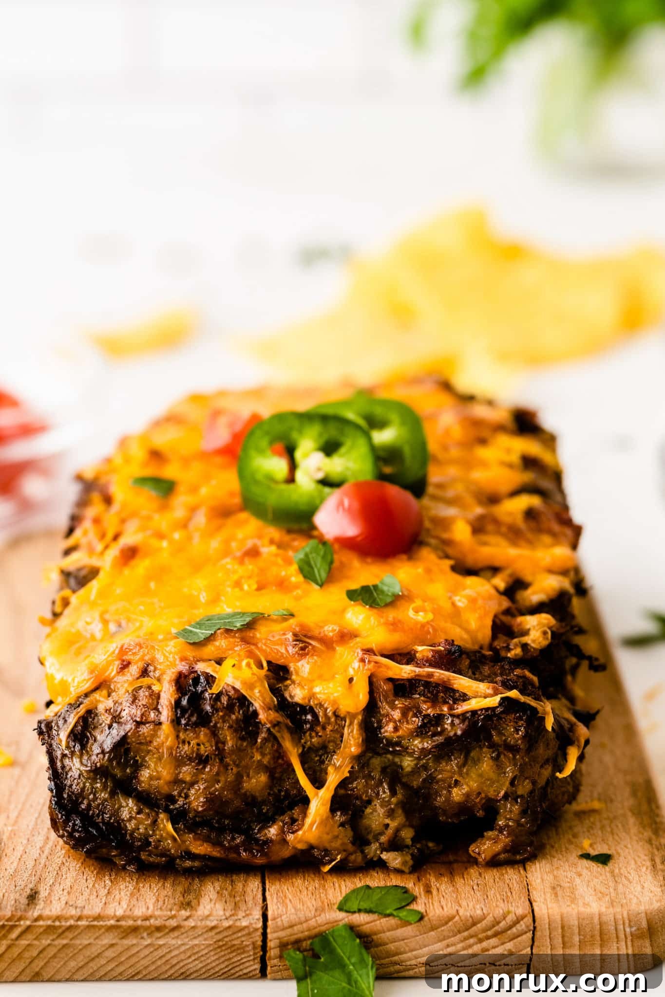 Front view of the cooked taco meatloaf with melted cheese and sliced jalapeños on top, garnished with fresh cilantro.
