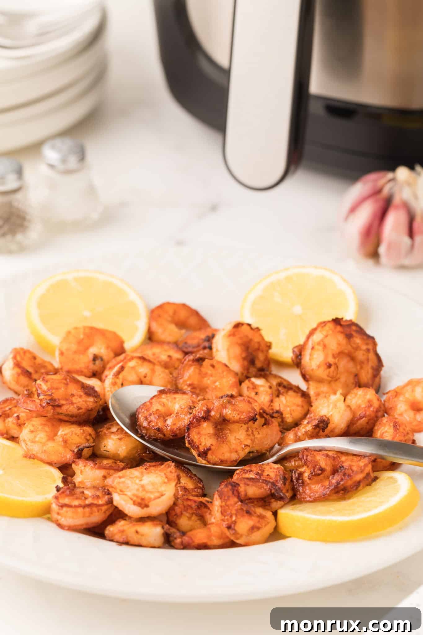 A bowl of cooked air fryer shrimp with lemon.