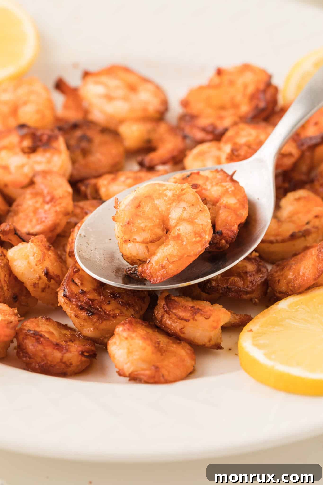 cooked air fryer shrimp on plate with lemon.