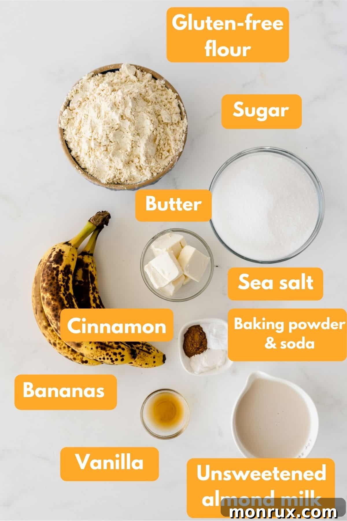 Various ingredients for banana cake laid out in small bowls, including flour, sugar, mashed bananas, and eggs.