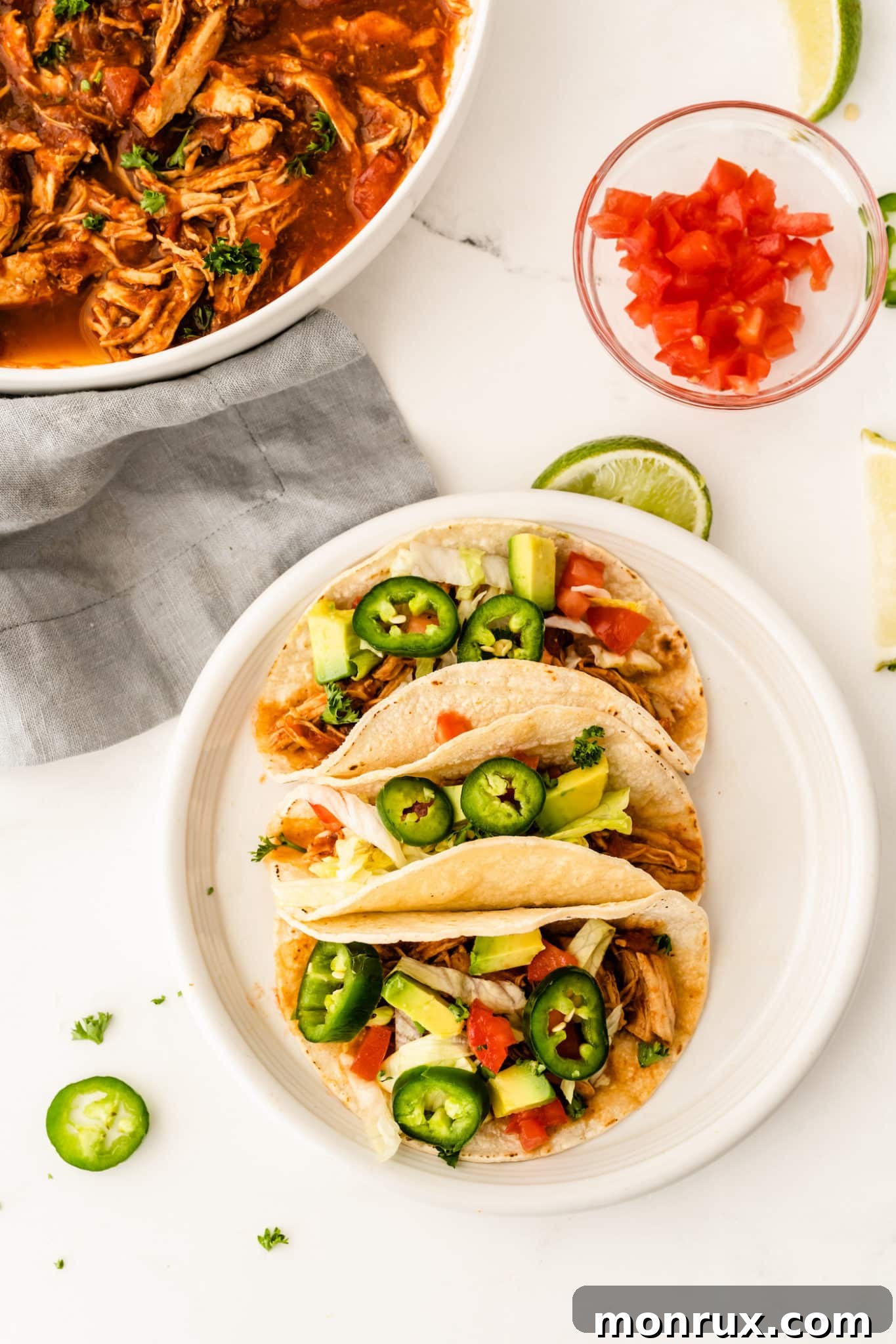 A plate of chicken tinga tacos with jalapenos.
