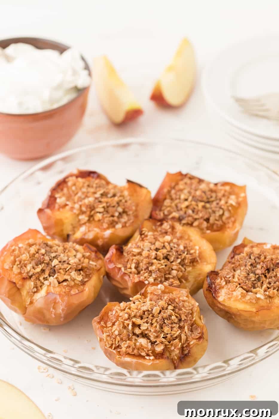 Air fryer baked apples with oat filling on a plate, garnished with a sprinkle of cinnamon.